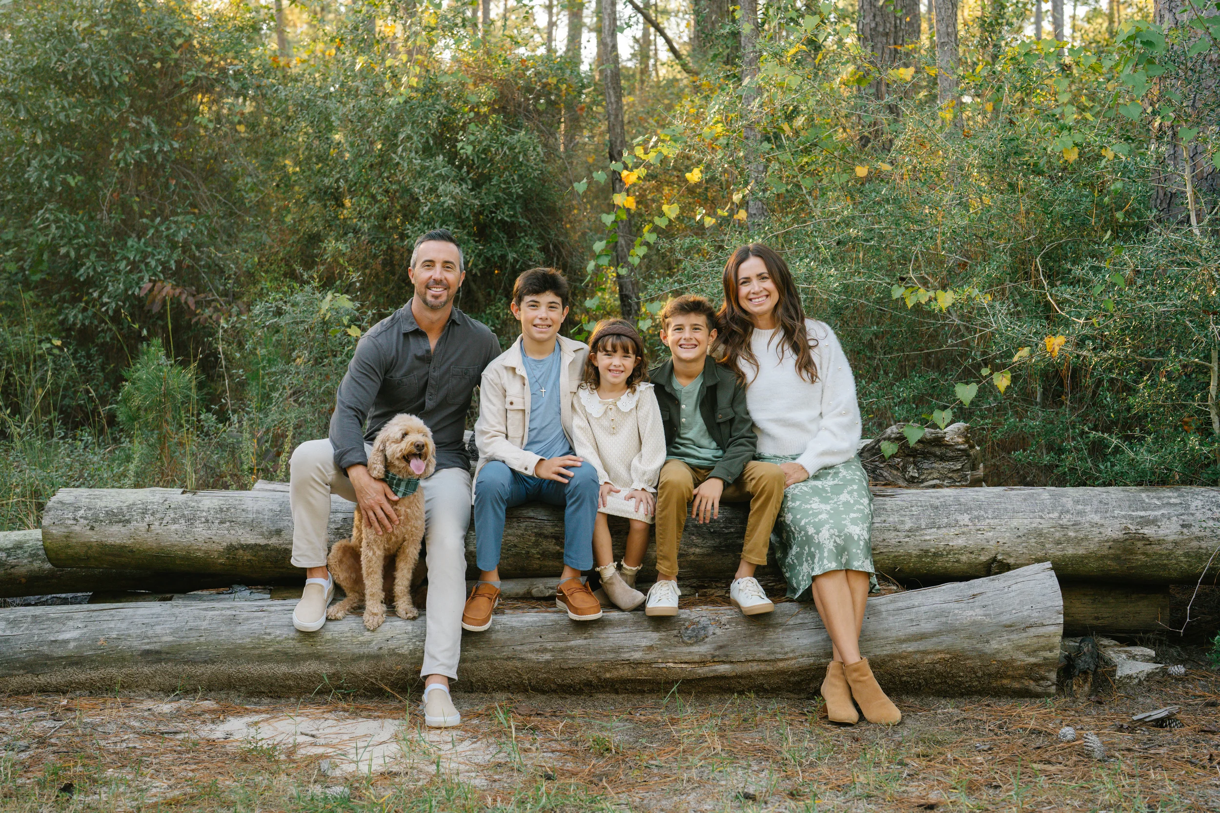 Freeport family photographer capturing a family portrait in a wooded outdoor setting