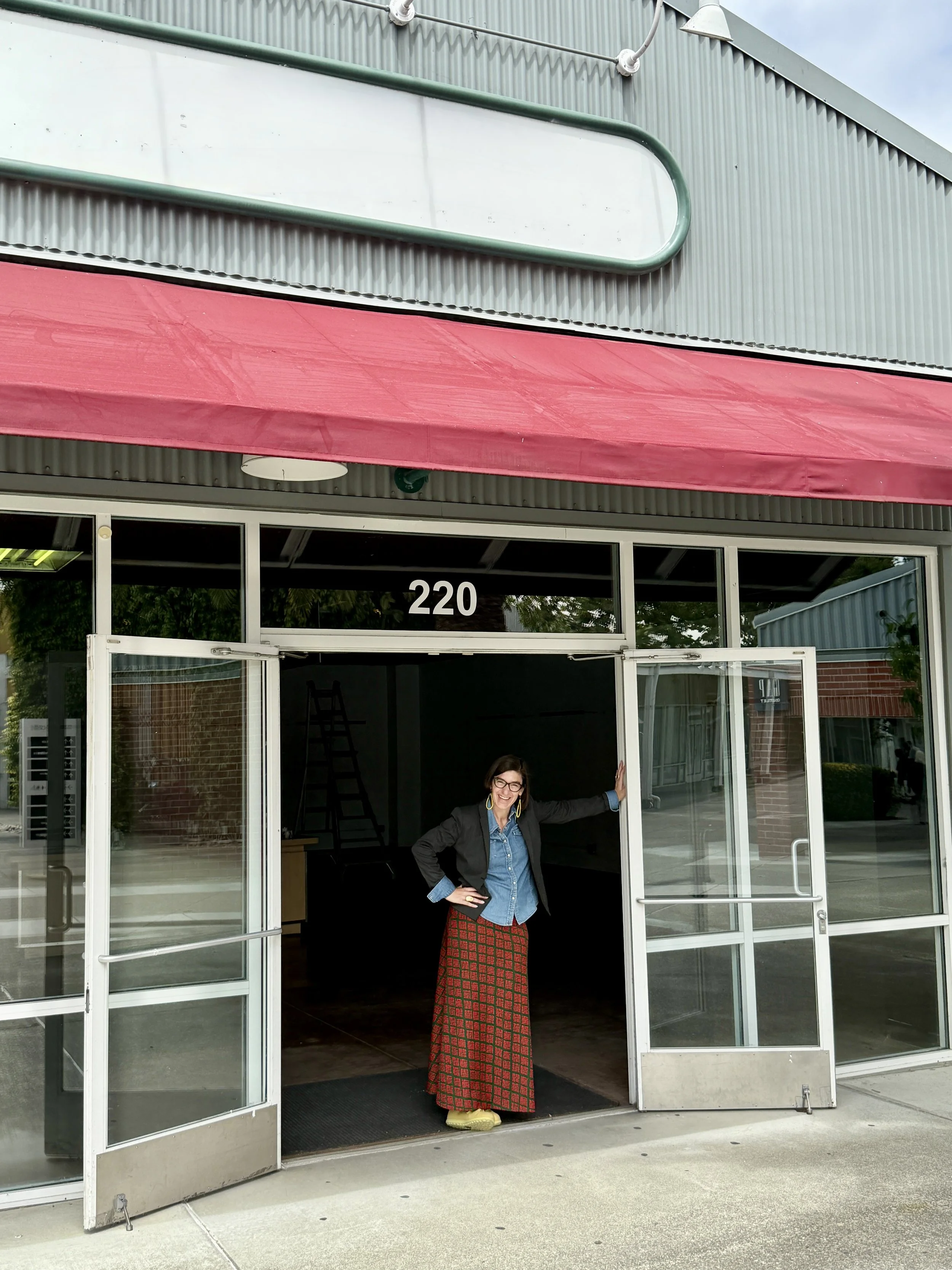 Woman leaning against door frame of large building