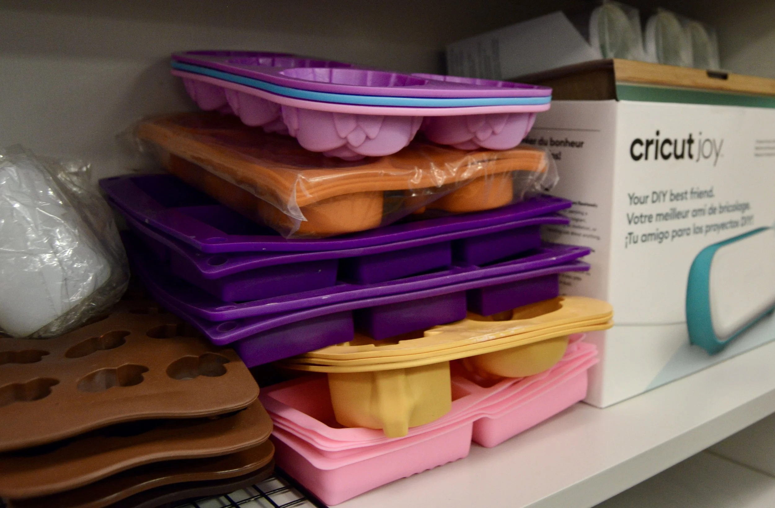Stack of colorful soap molds with cricut joy box to the right