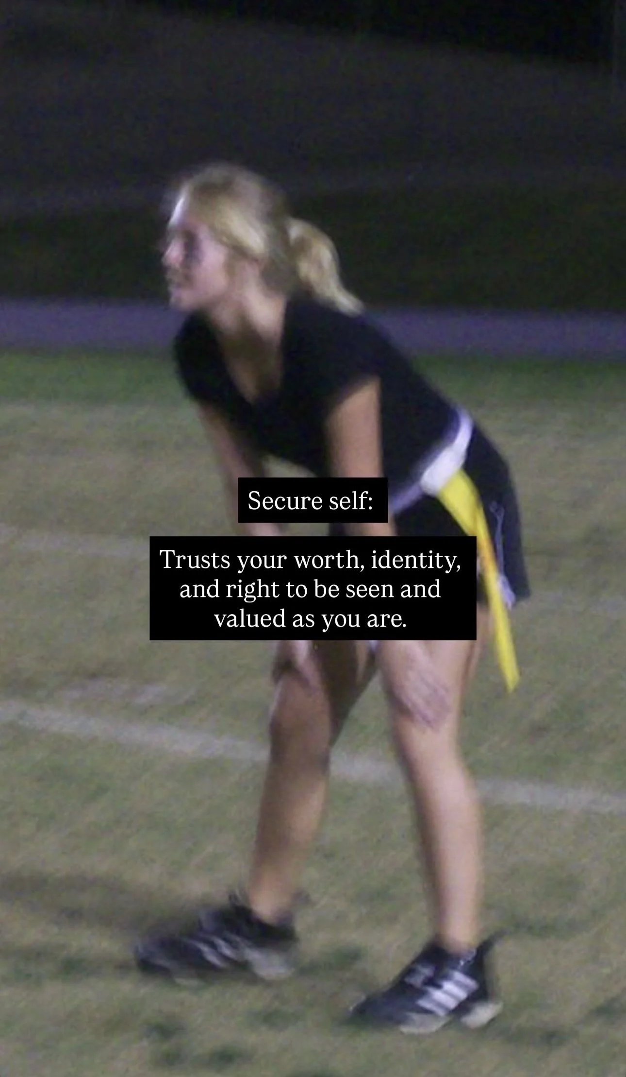 A person in athletic clothing bending forward on a grassy field at night, with overlaid text that reads: 'Secure self: Trusts your worth, identity, and right to be seen and valued as you are.'