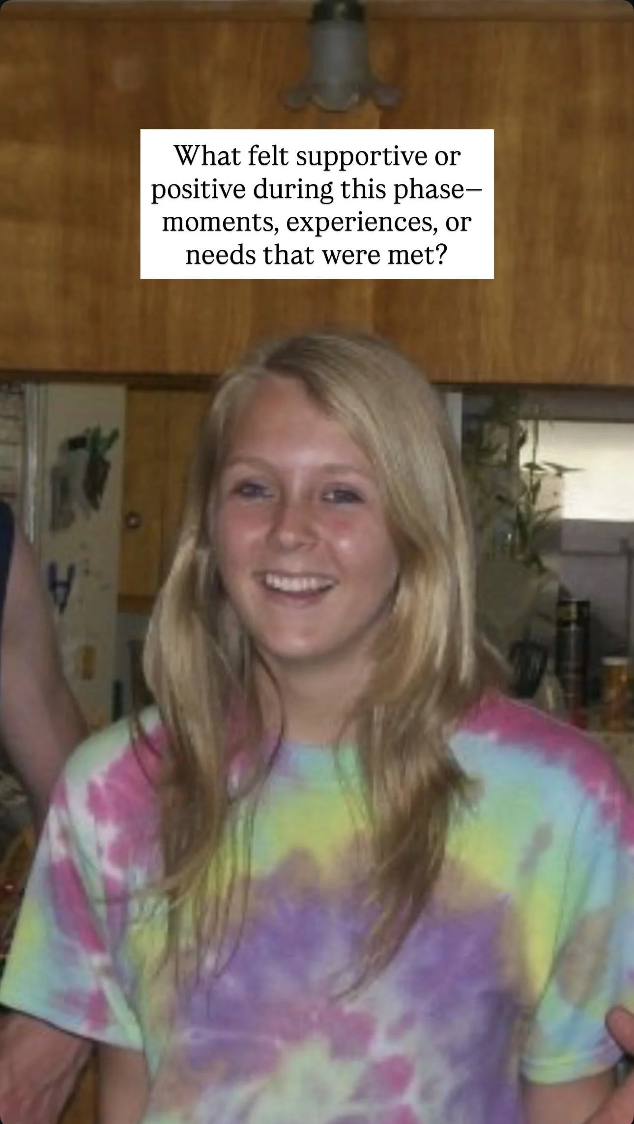 A young woman with long blonde hair smiling in a kitchen, wearing a colorful tie-dye t-shirt. A white text box above her head contains a question, asking about supportive or positive moments, experiences, or needs met during a particular phase.
