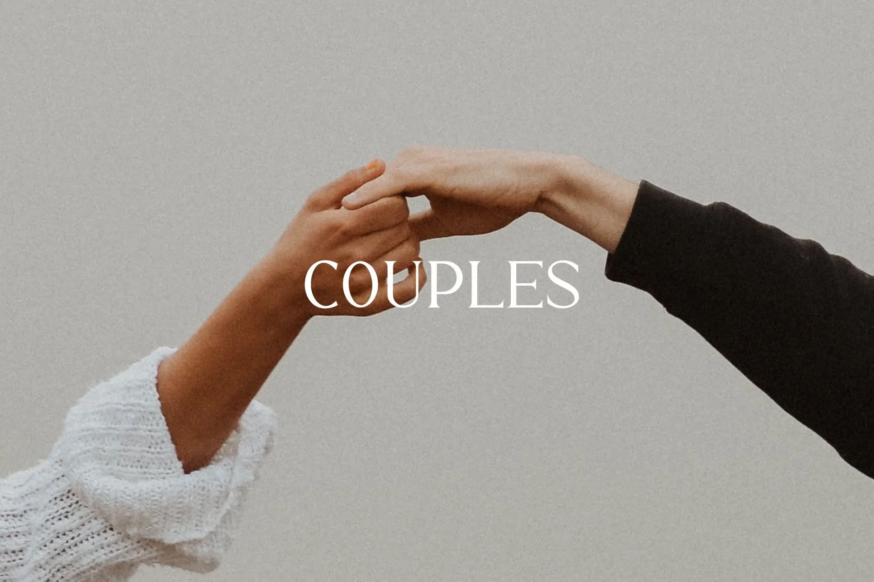Two hands, one with a bracelet, gently touching or holding each other, with the word 'COUPLES' overlaid in the center.