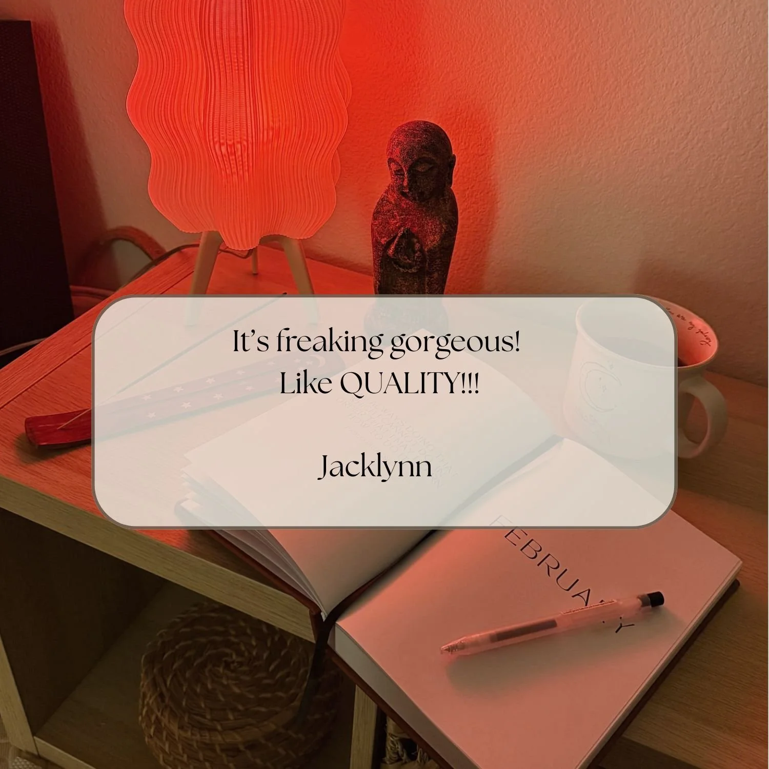 A cozy desk setup with a pink lamp, a small sculpture, a book titled 'February', a pen, and a mug, with an overlay of a review praising the quality of the lamp.