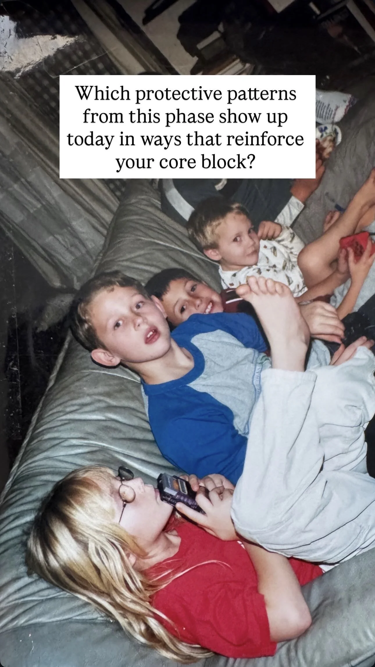 A group of children relaxing on a couch, with some holding remote controls or electronic devices, appearing casual and comfortable.