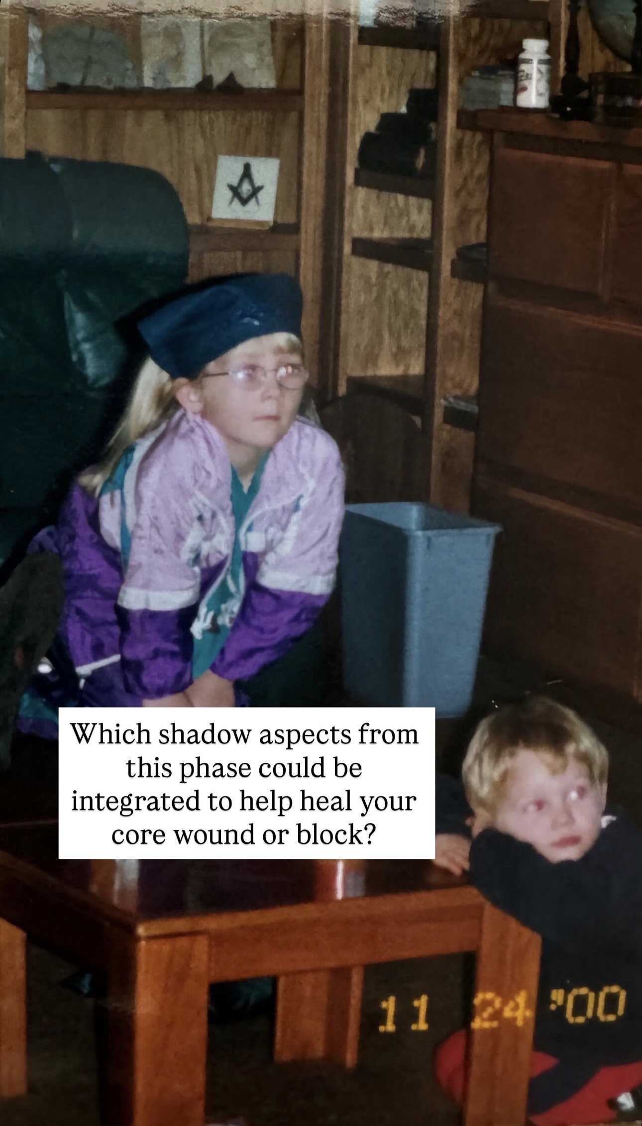 A young girl with glasses and a black headband, seated on a dark leather chair in a wooden room, gazing upward. A boy with light hair rests his chin on a wooden table, looking off to the side. The room contains wooden shelves with various items, incl