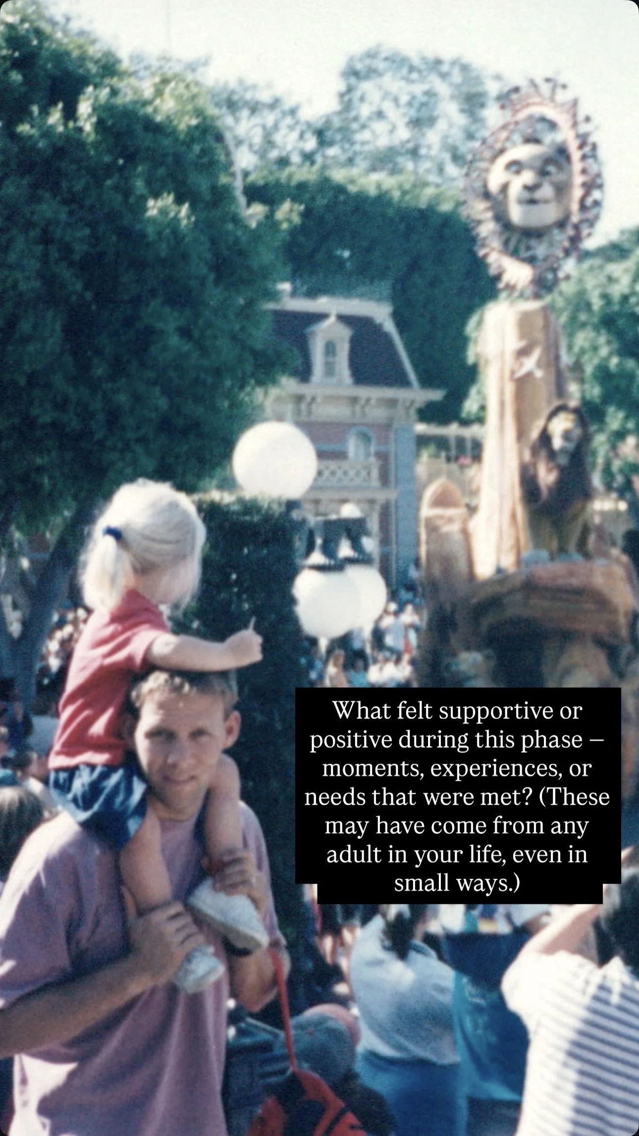 A man with a young girl on his shoulders in a crowded amusement park or parade setting, with a large decorative figure resembling a lion or big cat face with a headdress in the background.
