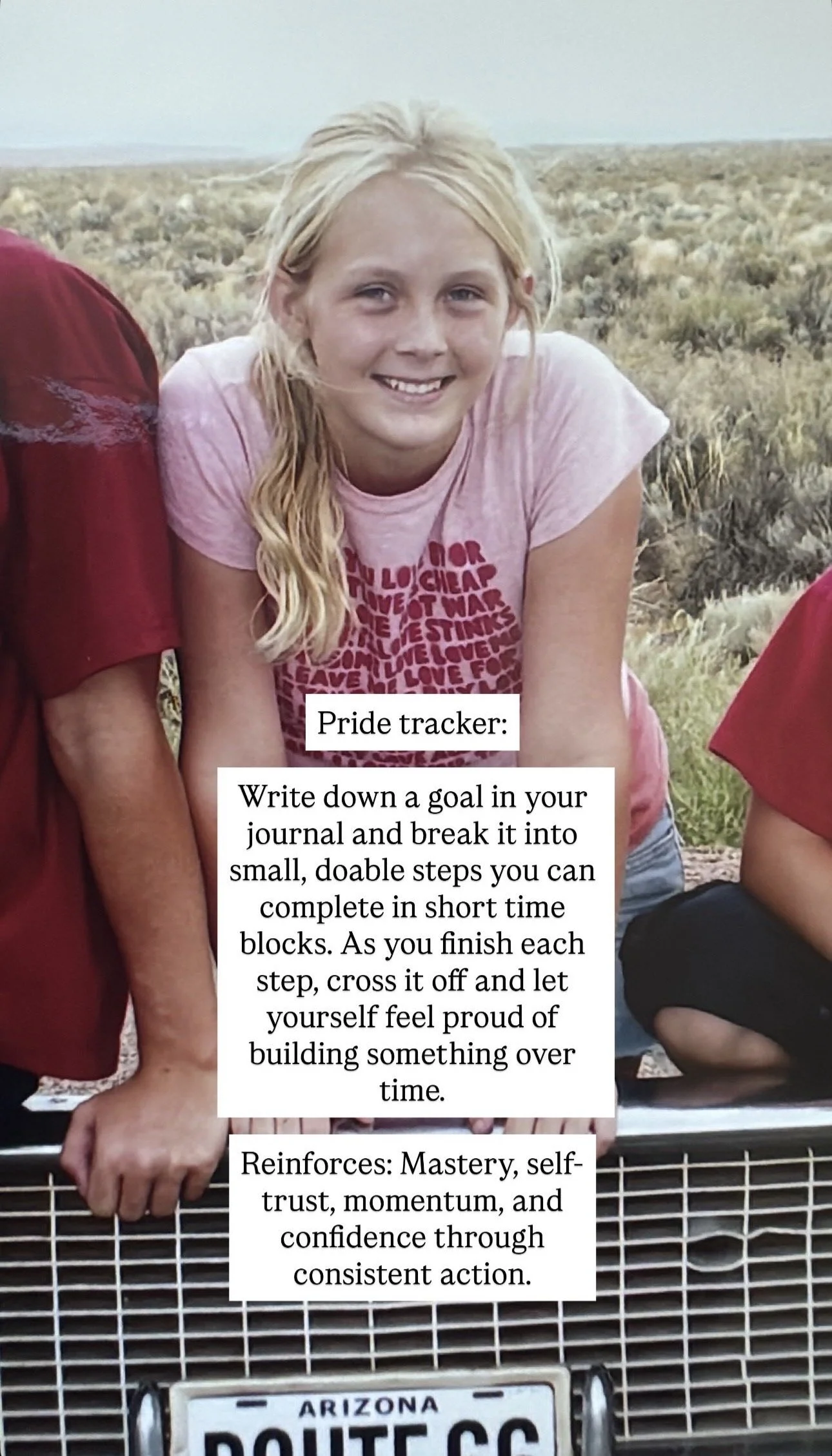 A young girl with blonde hair wearing a pink T-shirt, smiling, in a desert landscape. Beside her, there is a person wearing a red shirt, and part of another person in red is visible. The girl is leaning on the front of a vehicle with an Arizona licen