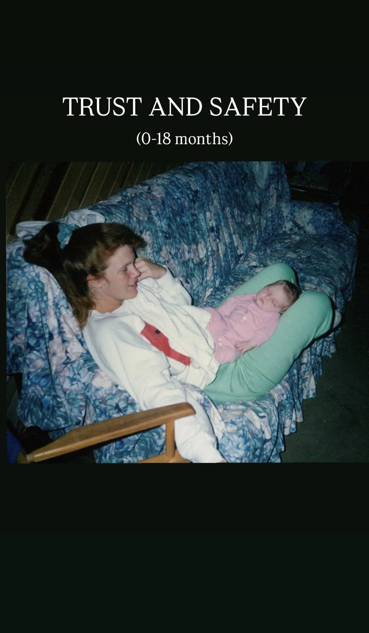 A woman with brown hair lying on a blue floral couch with a baby in a green infant seat on her lap, both smiling and looking at each other.