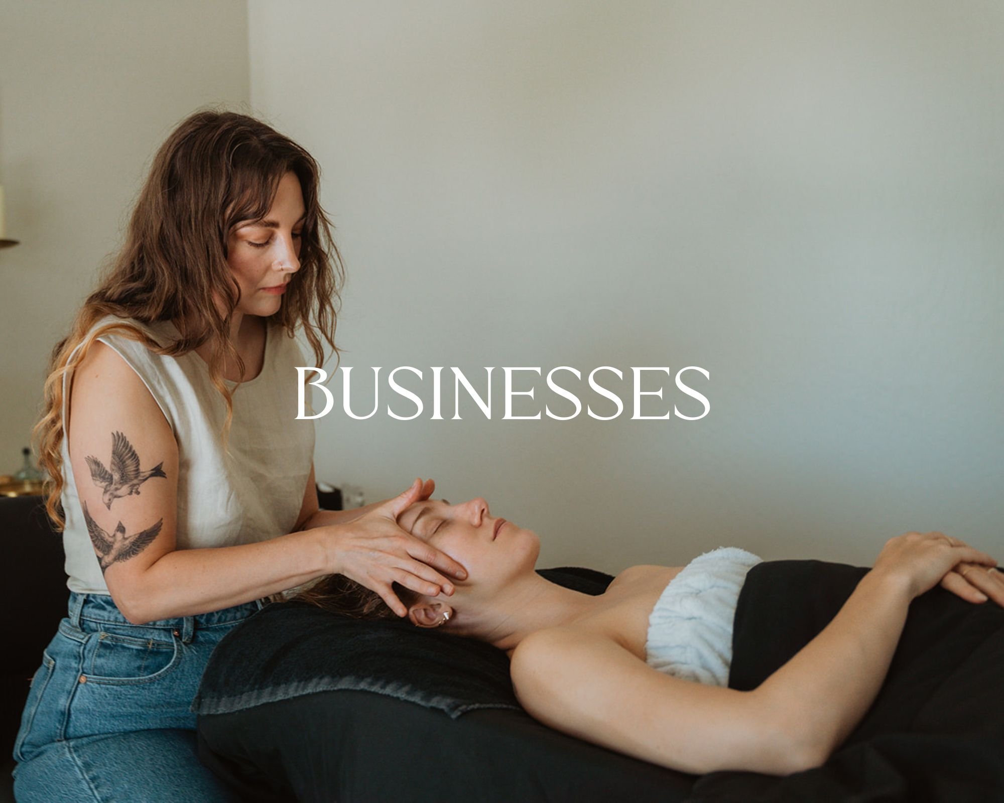 A woman receiving a facial massage from a massage therapist in a spa or wellness center, with the word 'BUSINESSES' written across the center.