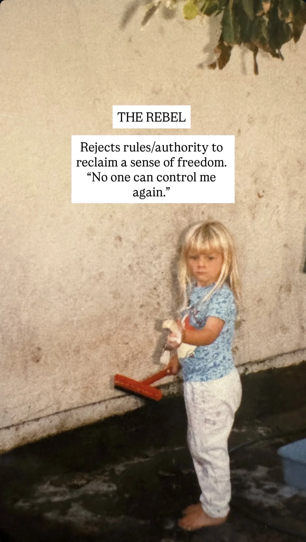 A young girl with blonde hair standing barefoot on a concrete floor, wearing pajamas and holding a paint roller, next to a textured wall with a quote about the rebel.