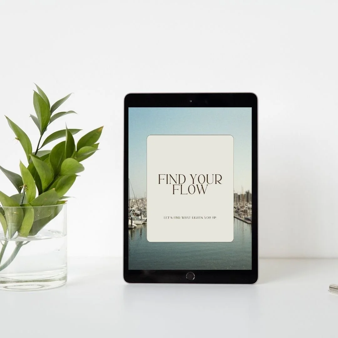 A tablet with a screensaver that says 'Find Your Flow' and a subtitle 'Let's find what lights you up,' placed on a white surface next to a glass pot with a green plant, with a plain white background.