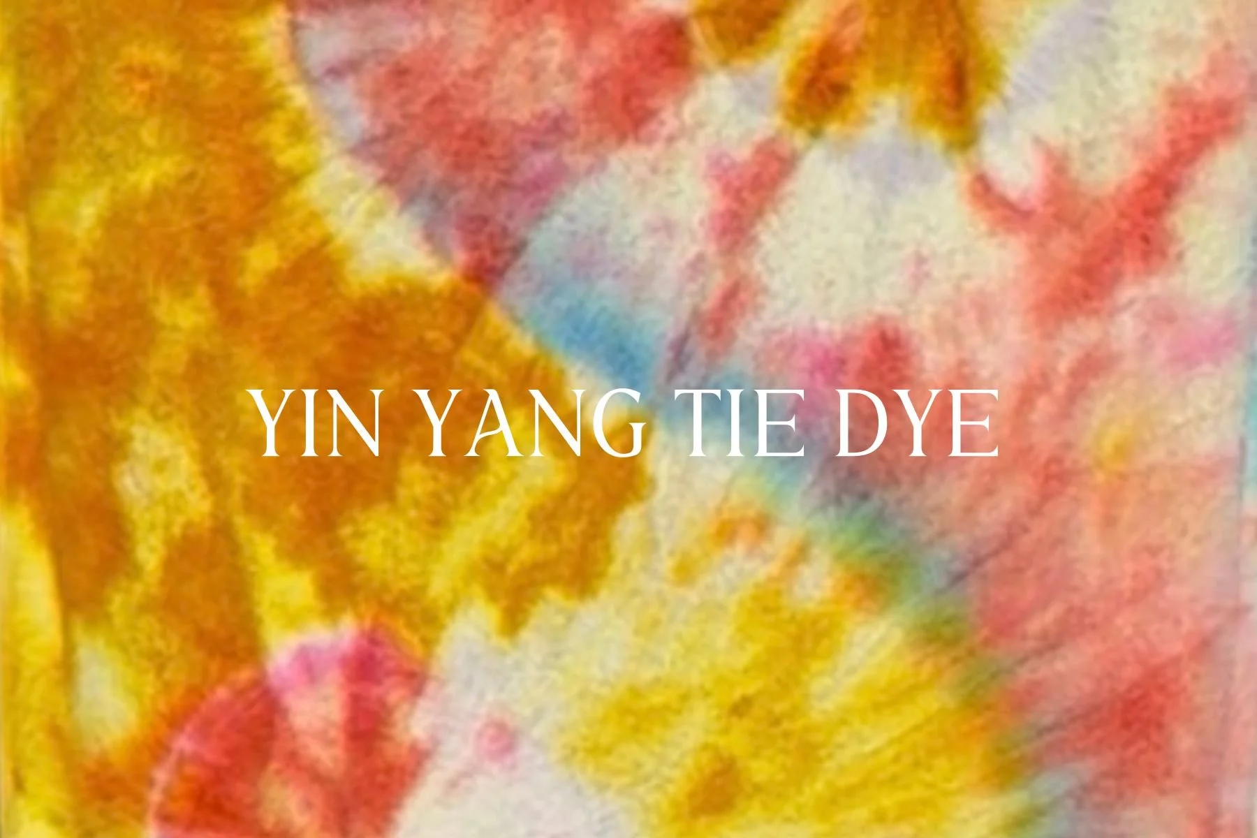 Close-up of tie-dye fabric with yellow, pink, blue, and orange colors and the text "YIN YANG TIE DYE" across the center.
