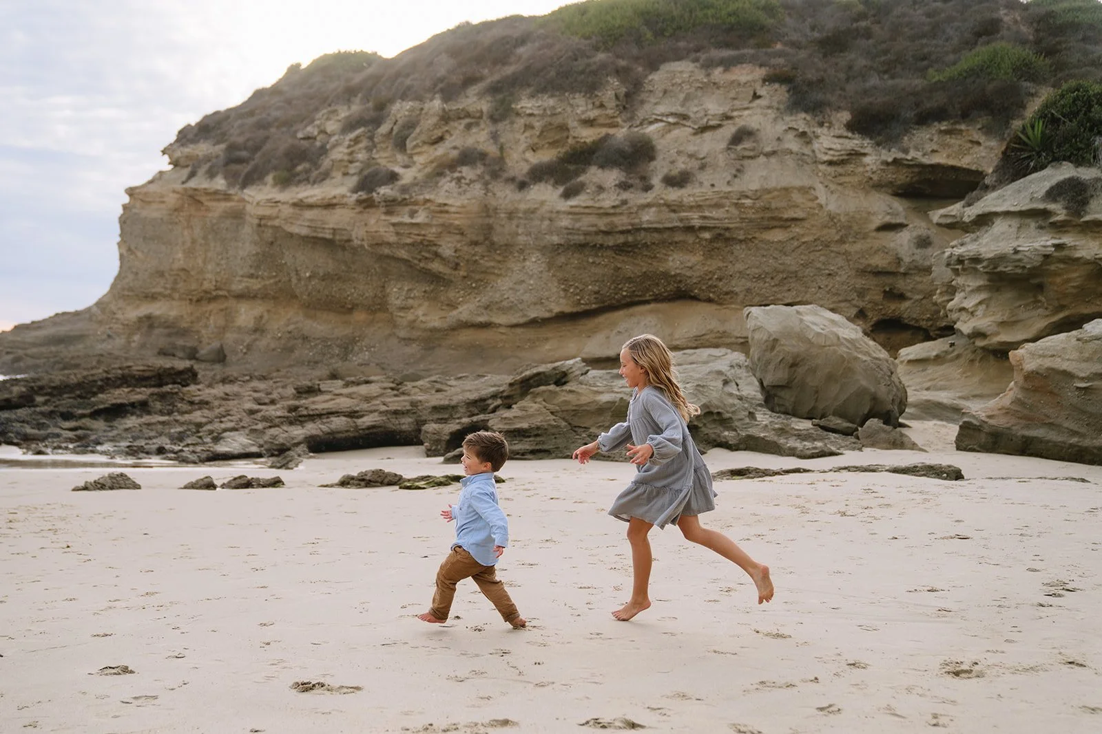 siblings chasing each other at the beach