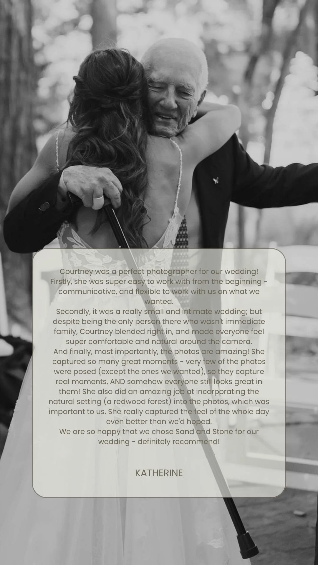 A black-and-white photograph of an elderly man with white hair, smiling and embracing a woman in a wedding dress who is holding a cane. The background shows a forest setting with trees.