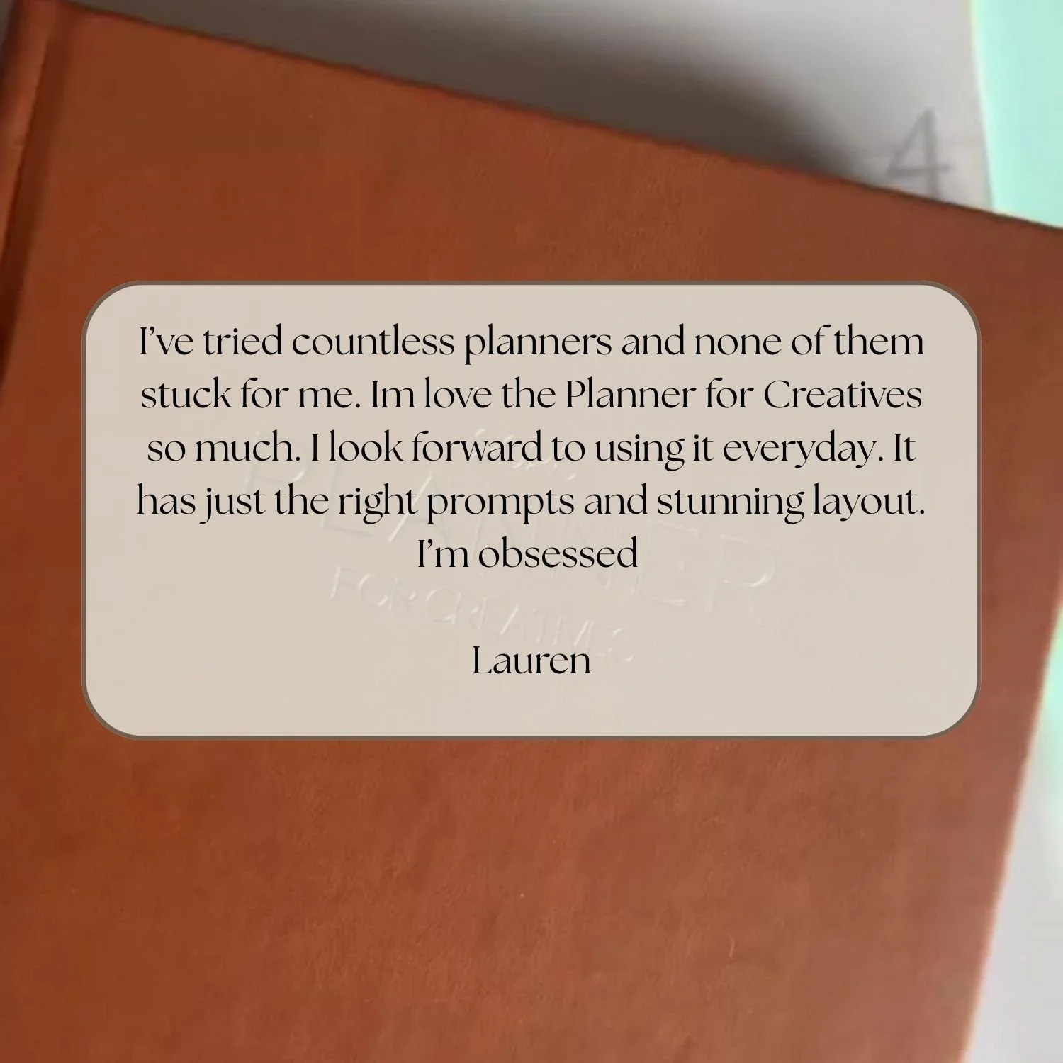 A note on a planner book cover expresses love for the Planner for Creatives, highlighting its prompts and layout, signed by Lauren.