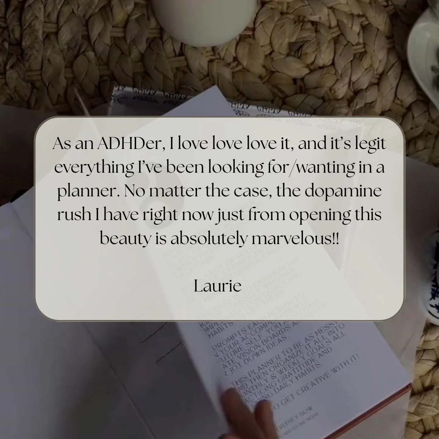 A handwritten note on a planner opened on a woven surface with a white cup and some papers around.