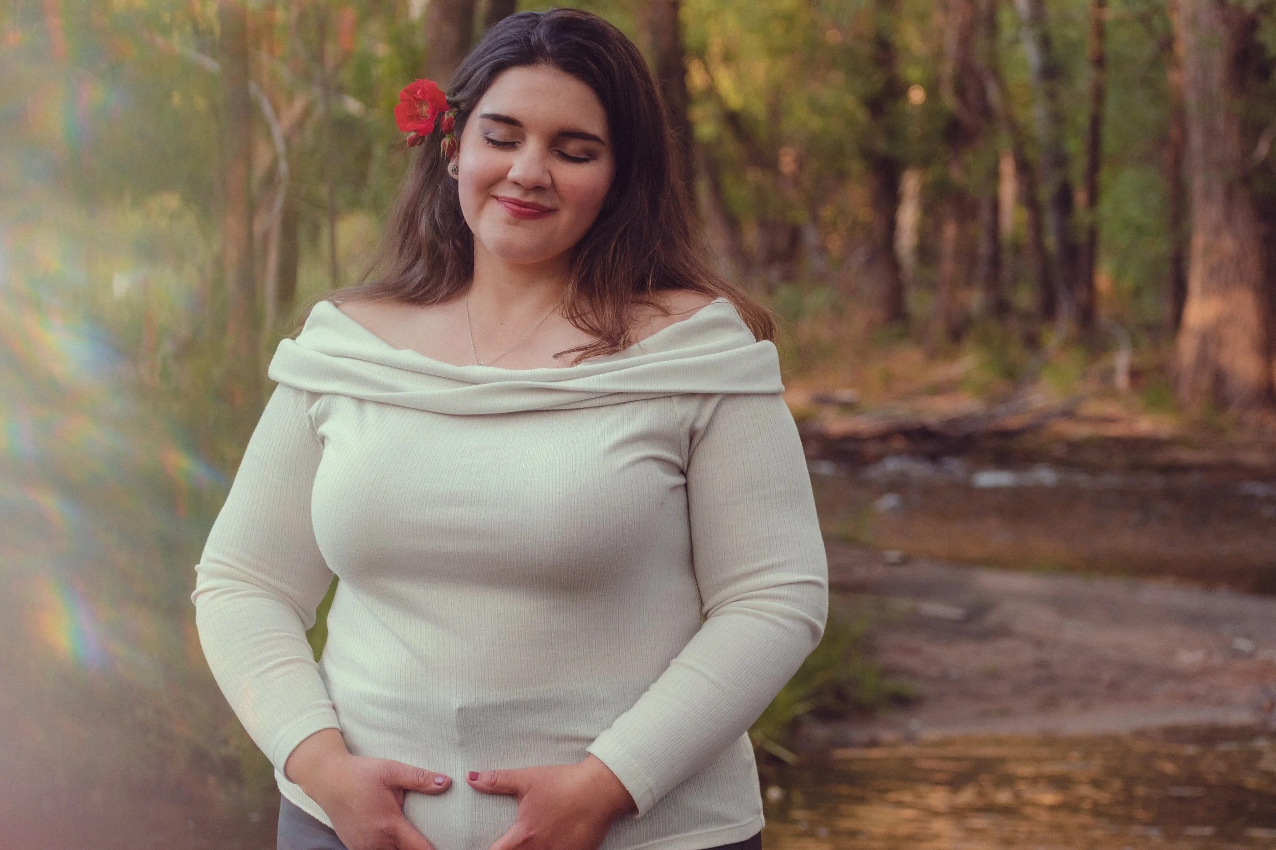 woman by river holding womb