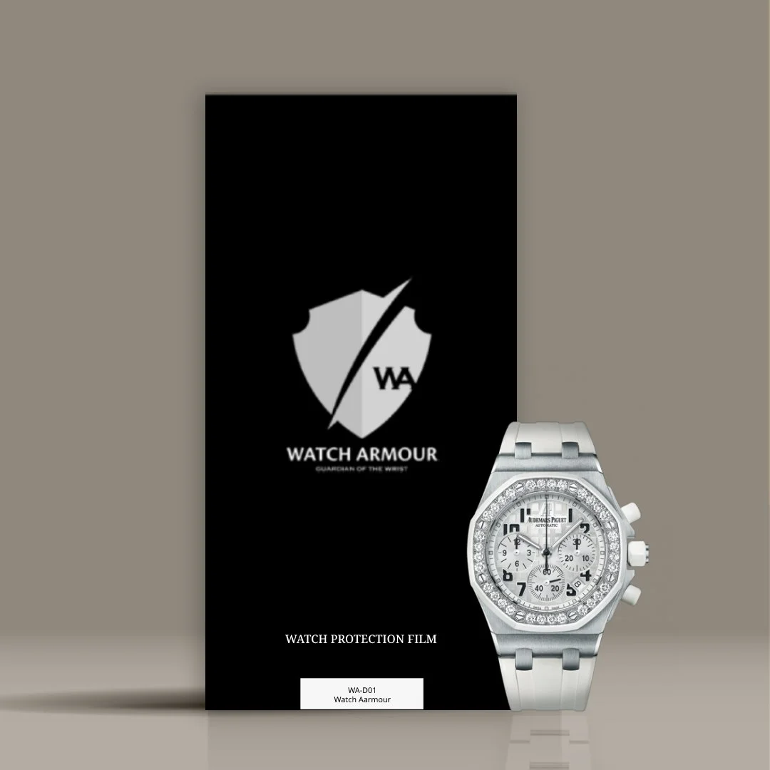 A silver wristwatch with a diamond-encrusted bezel placed in front of a black Watch Armour protection film package. The package has a shield logo with a diagonal line and the text "WATCH ARMOUR" and "GUARDIAN OF THE WRIST."