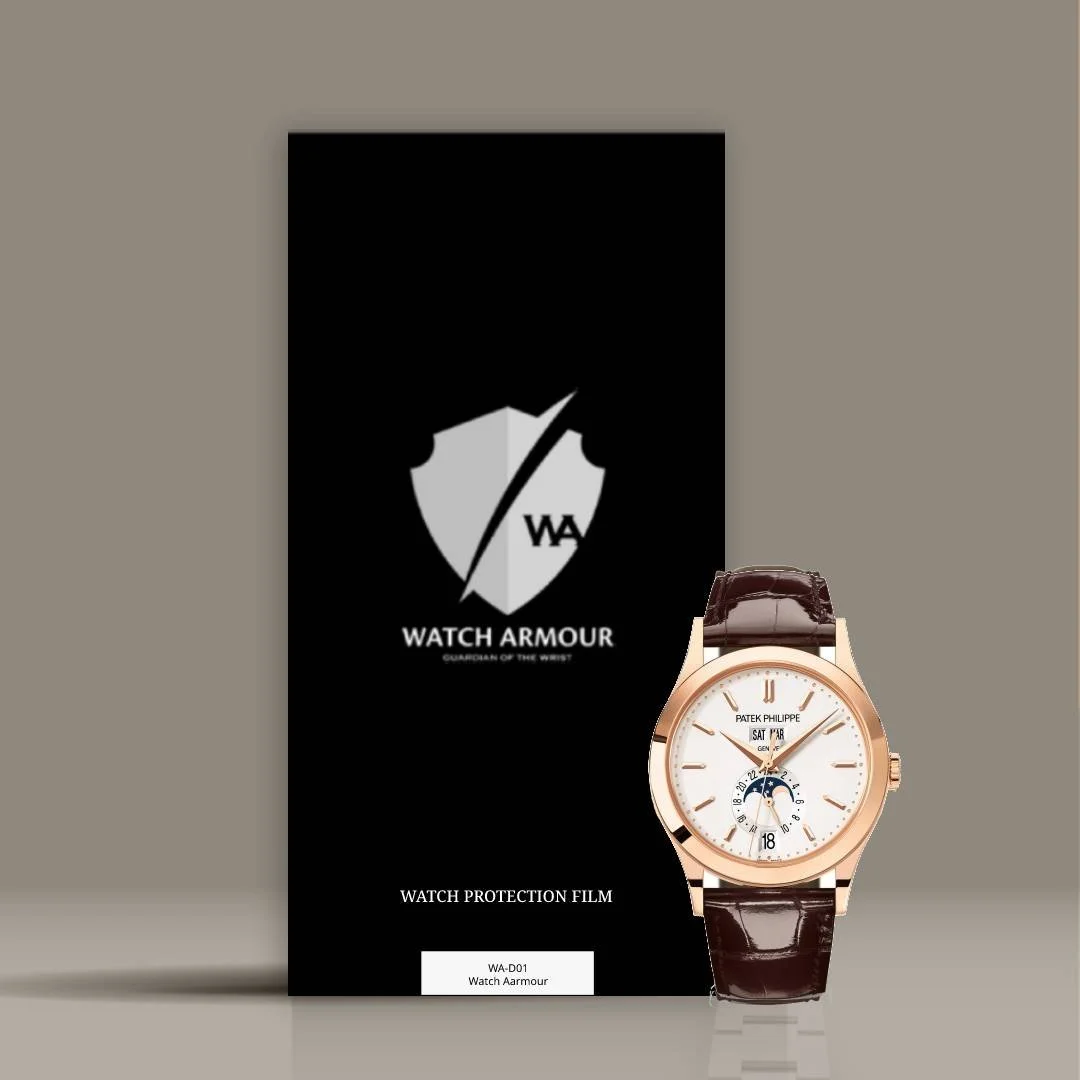 A Patek Philippe wristwatch with a white face, gold case, and brown leather strap, placed in front of a black Watch Armour protection film packaging.