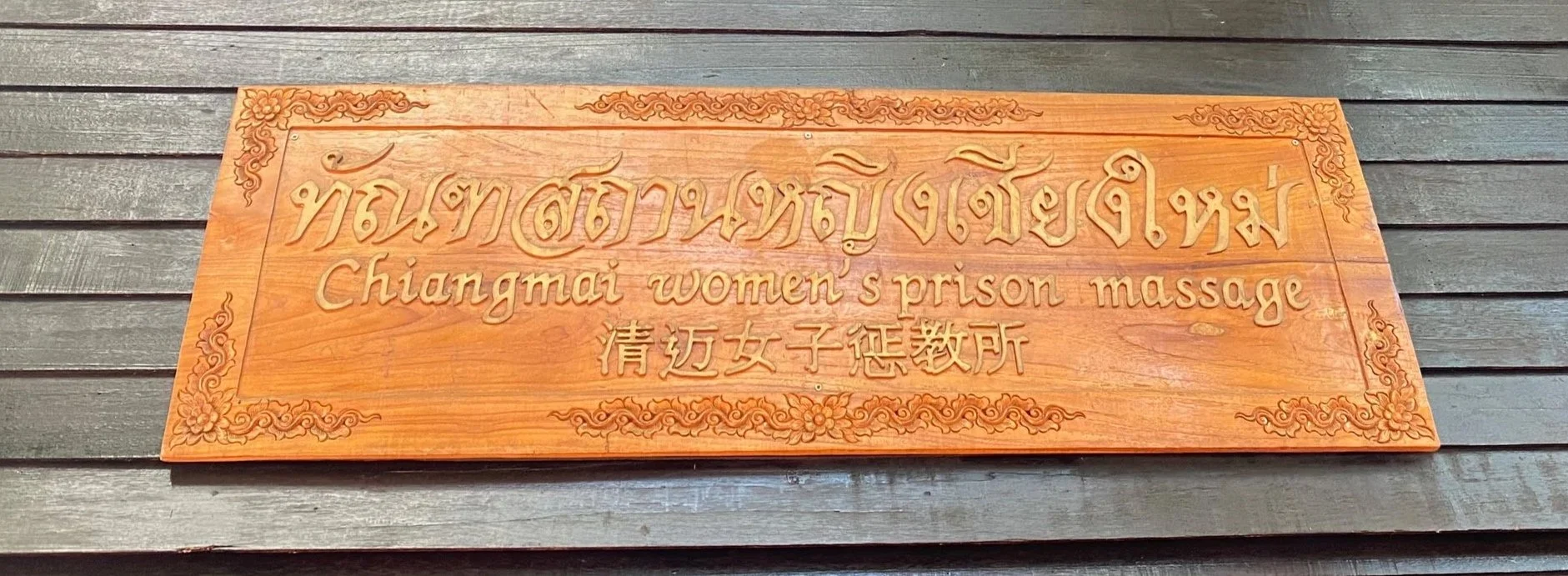 Wooden "Chiang Mai Women's Prison Massage" sign.