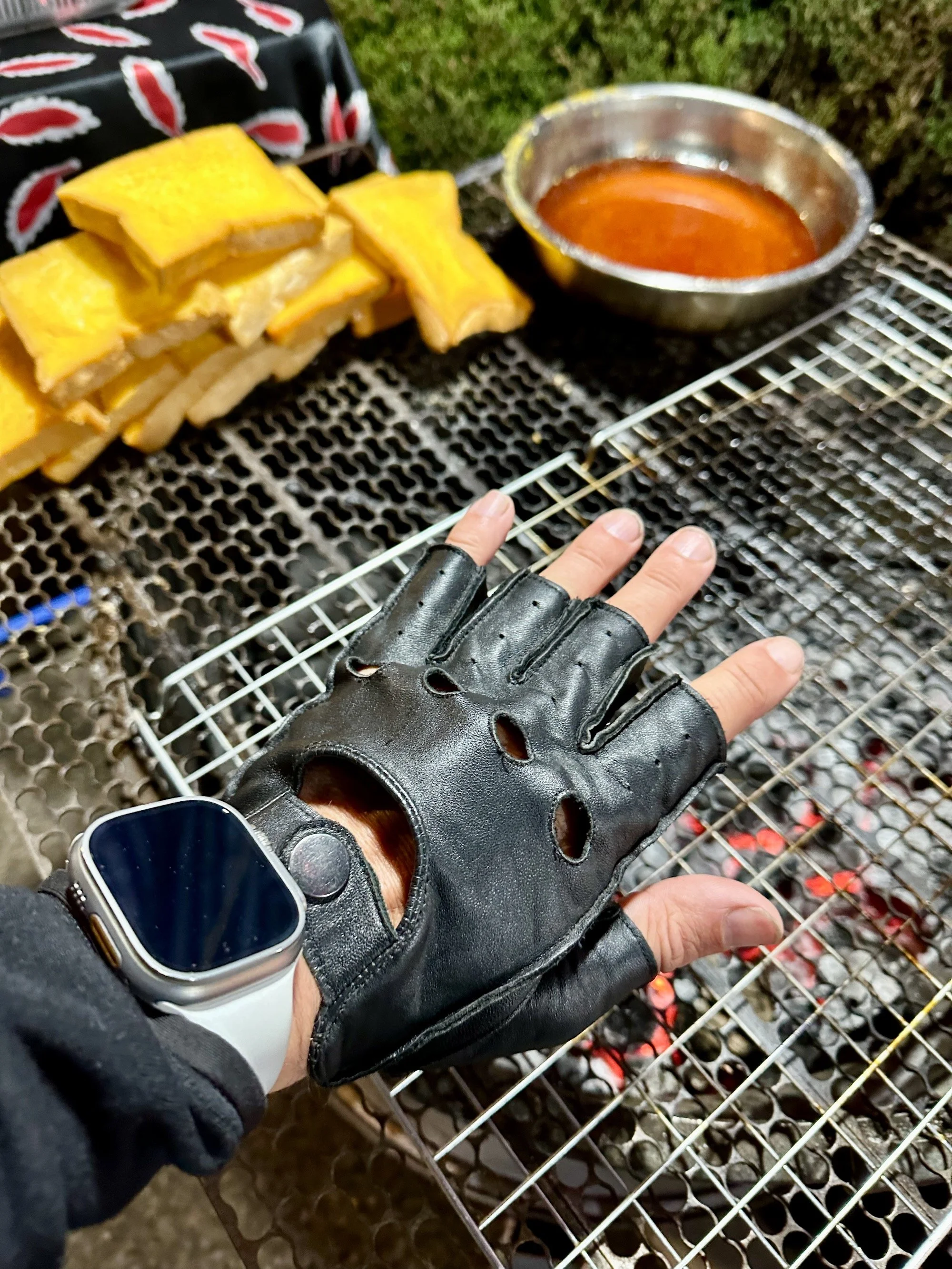 The author warming his hands over a charcoal grill.