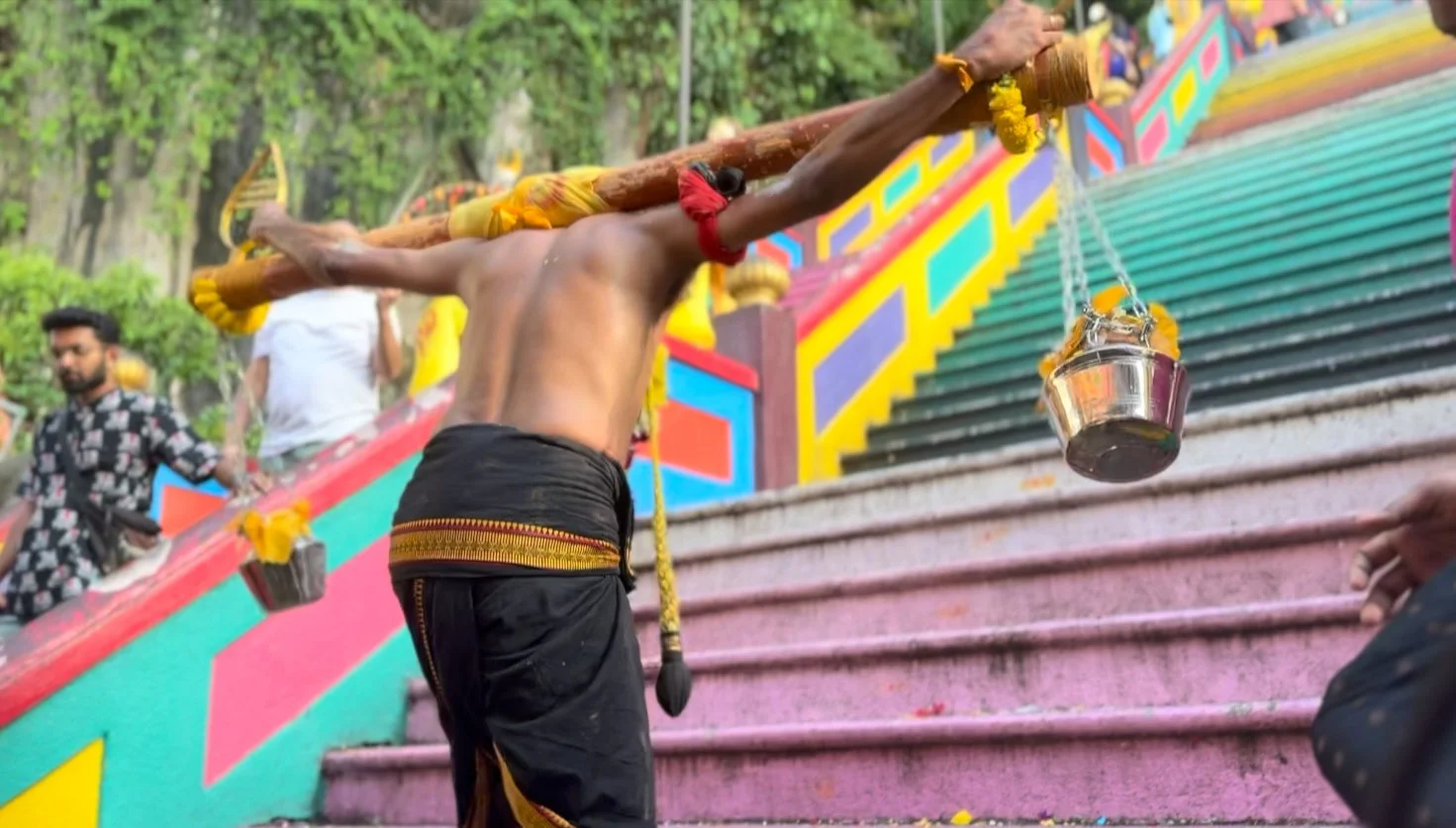 A Thaipusam pilgrim makes the final ascent up the stairs to the cave temple.