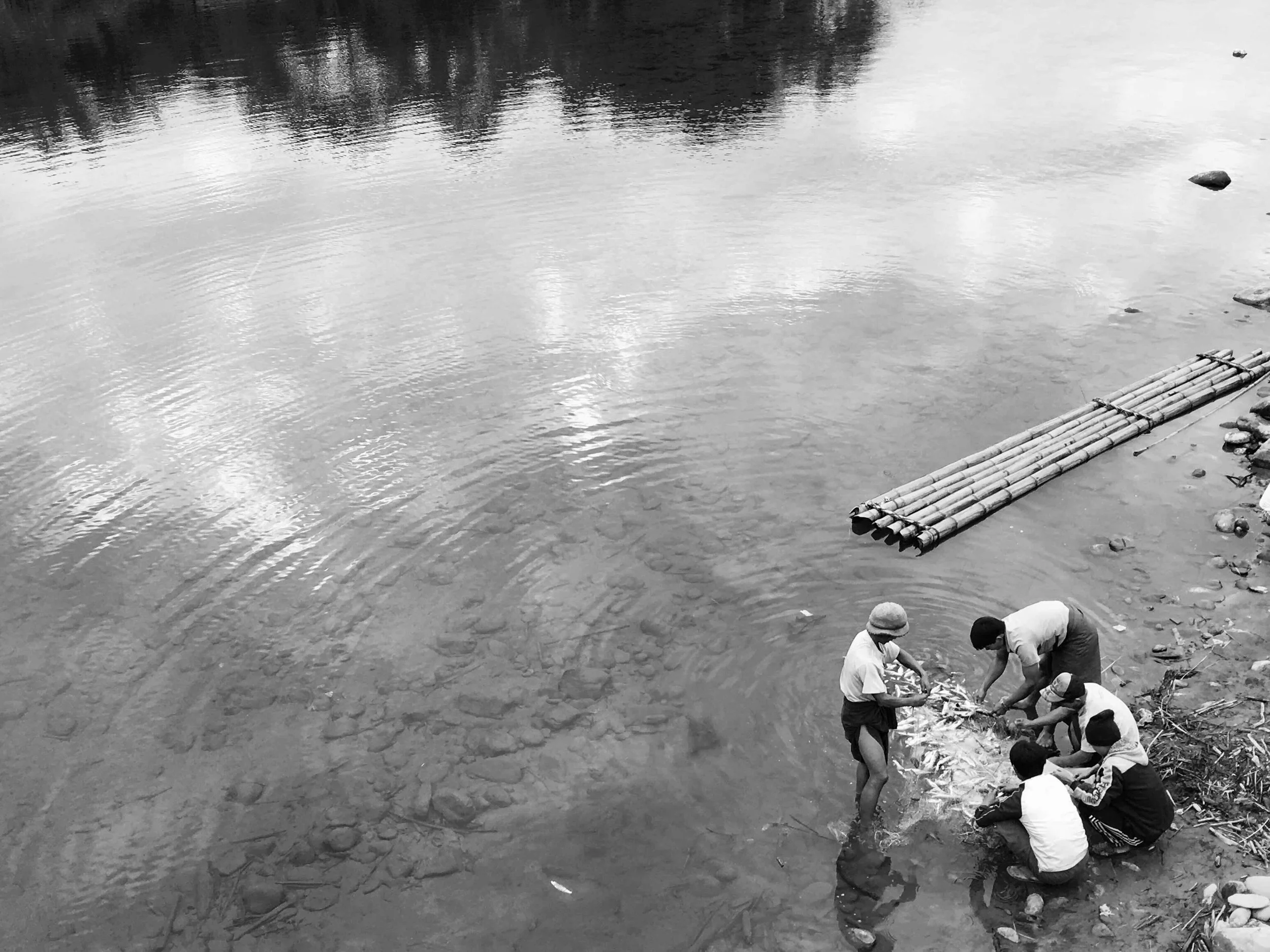 Villagers catching fish at the riverside.