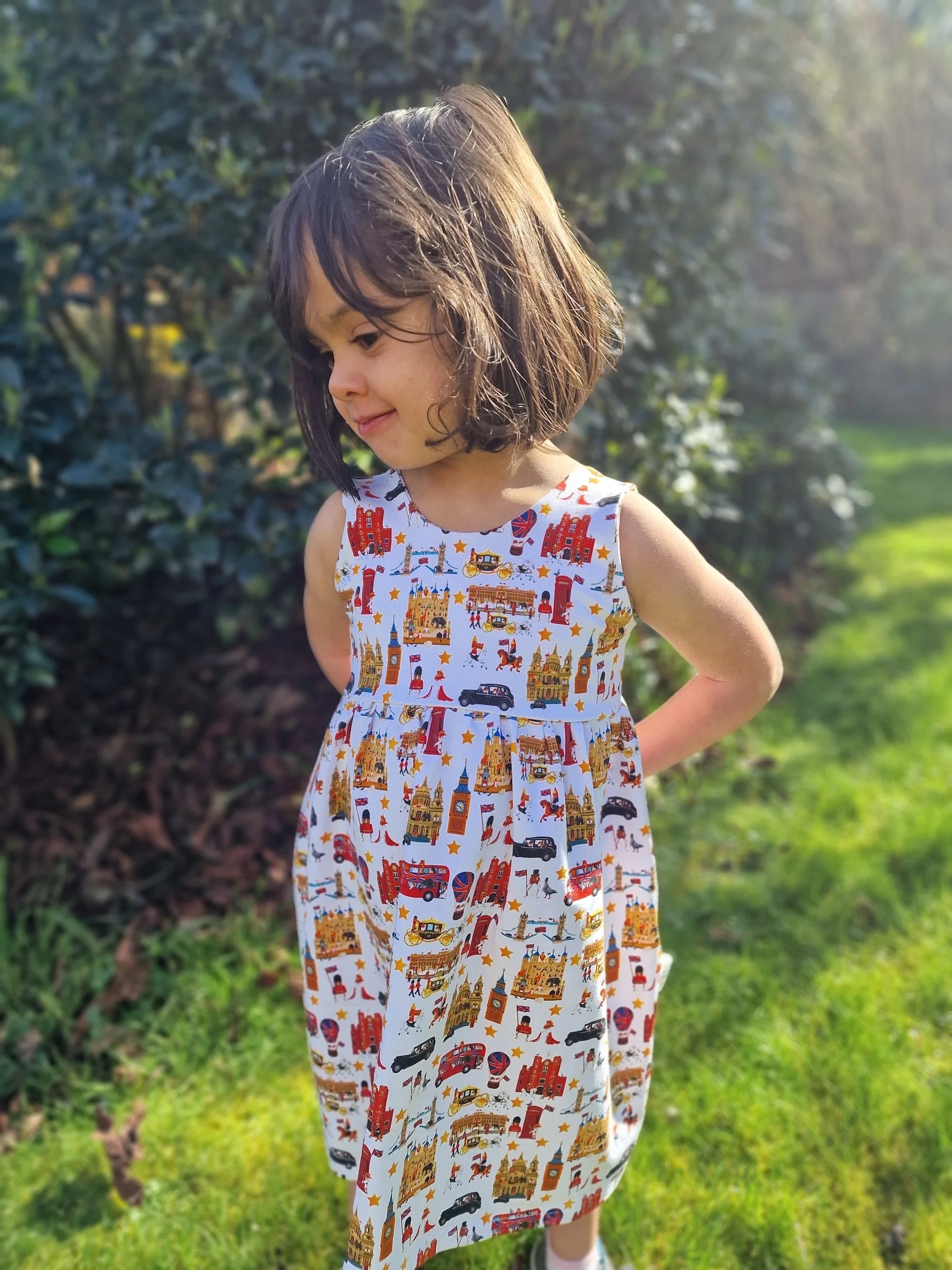 Little girl wearing traditional luxury dress, of British brand, Peckish Goose