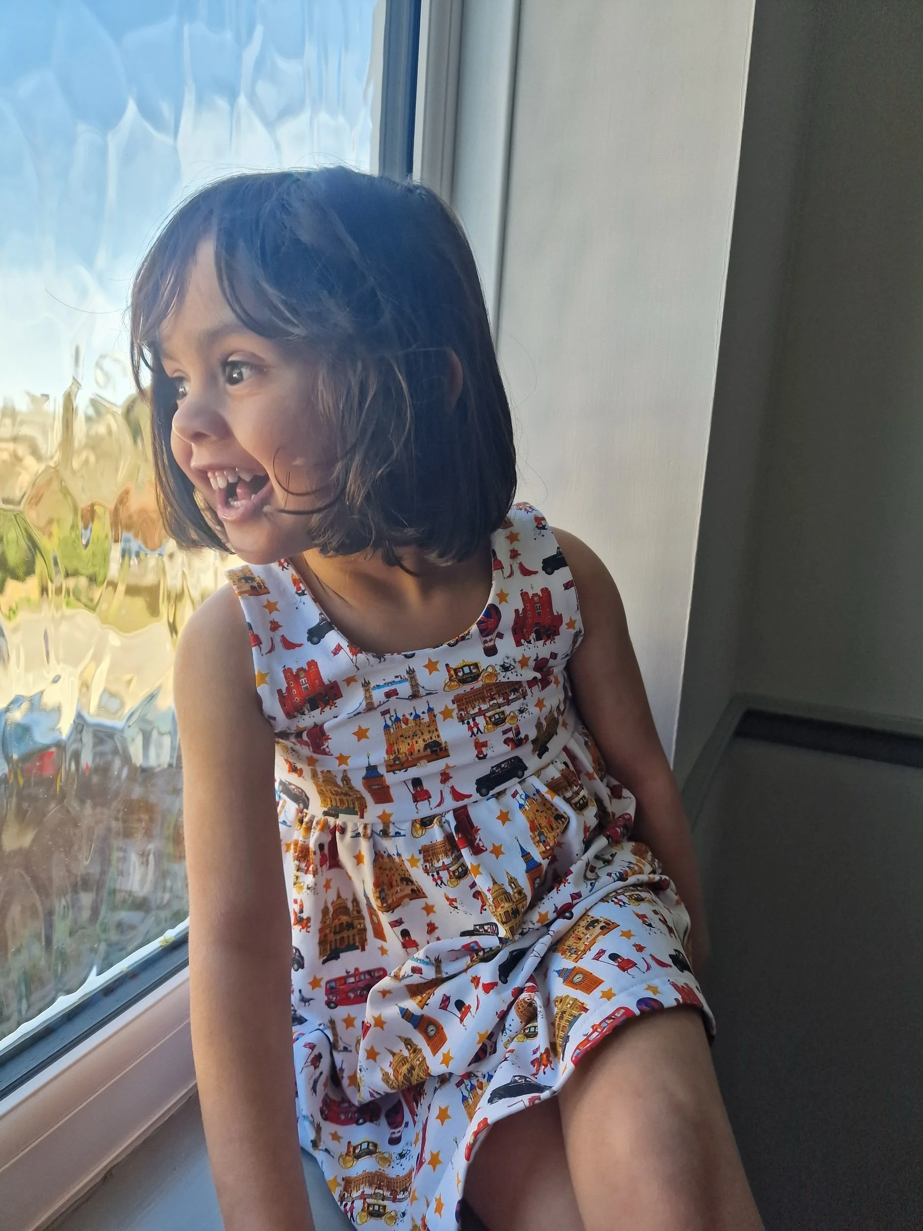 Little girl wearing London dress from luxury British brand Peckish Goose