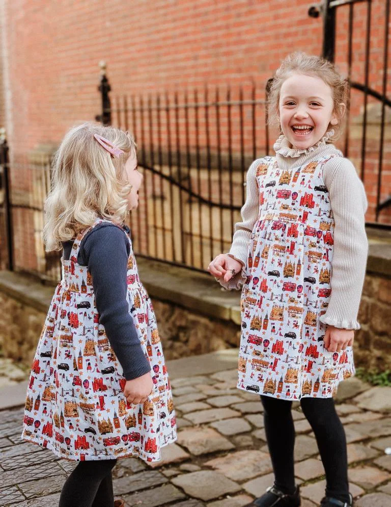 Little British girls wearing luxury British style London dresses. Dresses are organic cotton jersey and are made in England. Peckish Goose Children’s clothing. Luxury British brand.