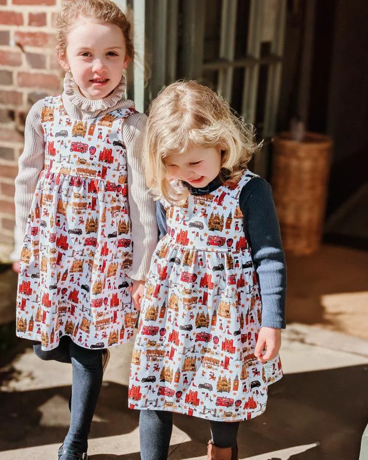 Two little British girls wearing London style organic matching dresses