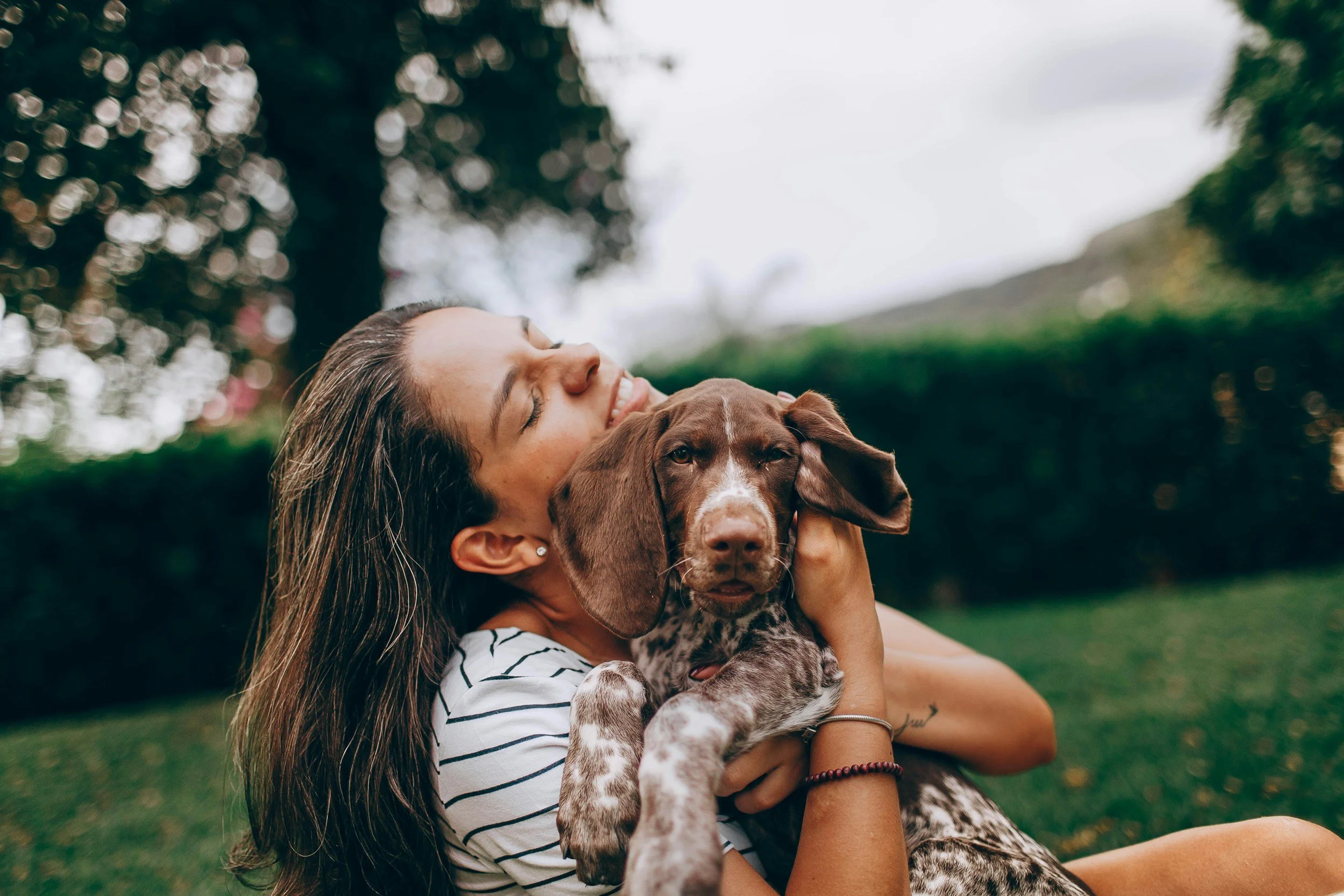 woman poses for pictures with pointer puppy