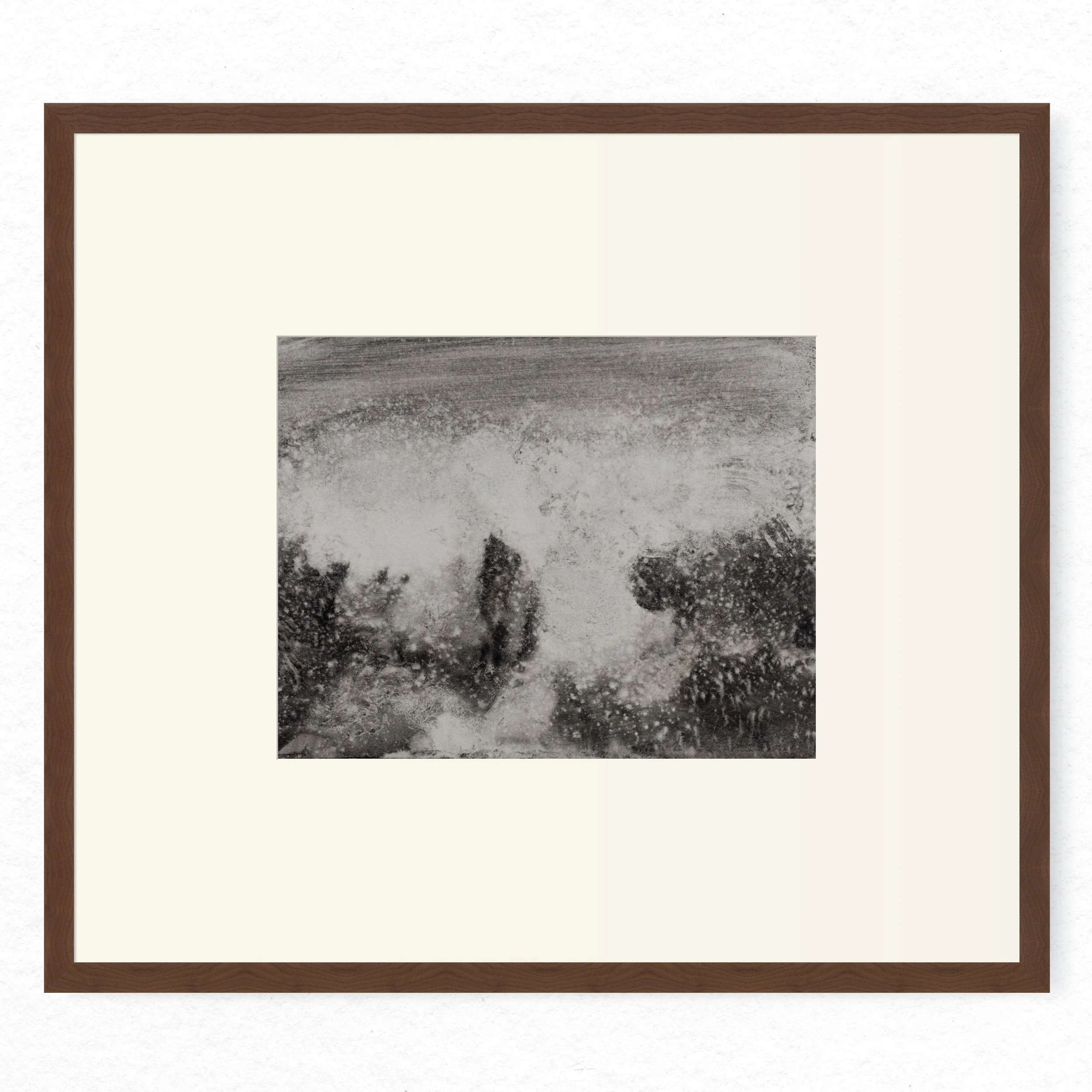 Shore 05 by Nicolas De Jesus — liquid charcoal and water on paper, waves crashing against rocks rendered in pale spray dominating the centre with dark rock masses at the base, hardwood frame with mount