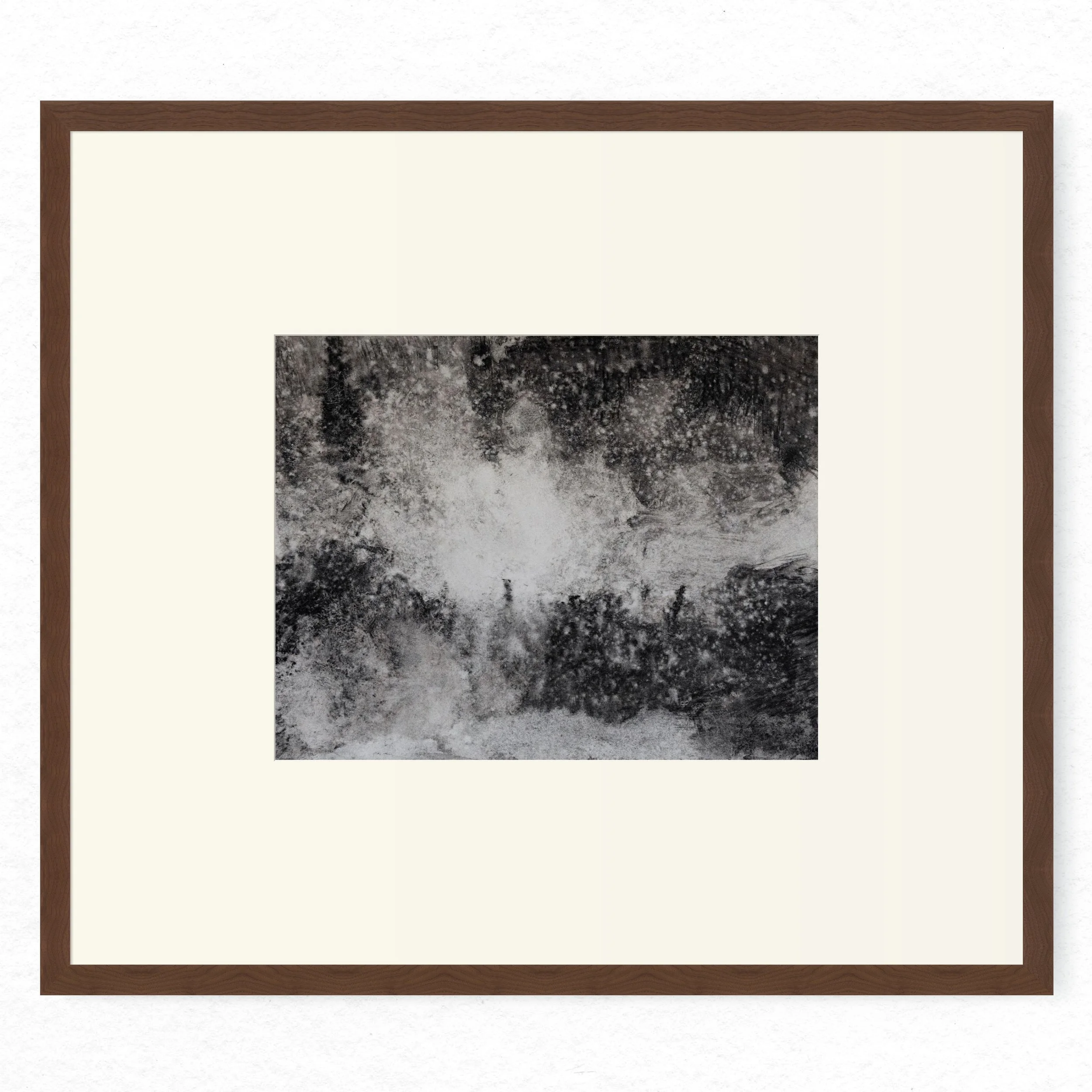 Shore 06 by Nicolas De Jesus — liquid charcoal and water on paper, waves crashing against rocks rendered in dense granular texture with a bright central plume of spray, hardwood frame with mount