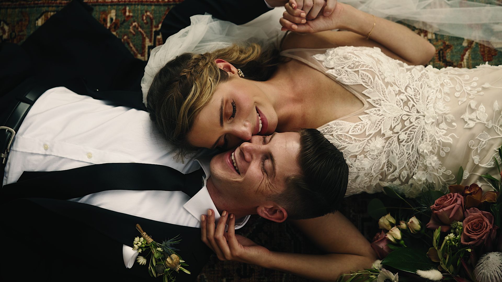 happy bride and groom pose on ground