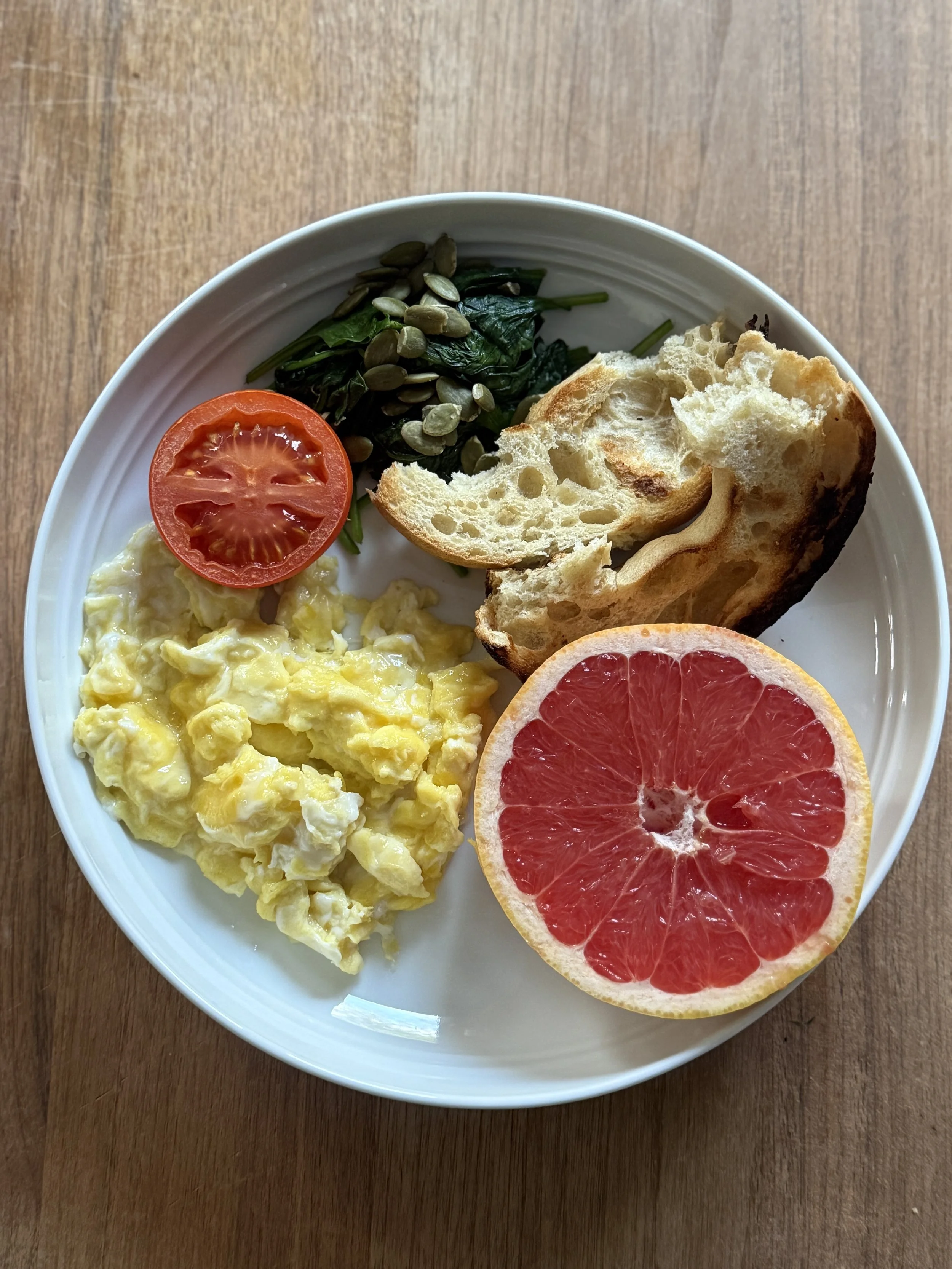 scrambled eggs, tomato, wilted spinach, pumpkin seeds, gluten free bagel and grapefruit