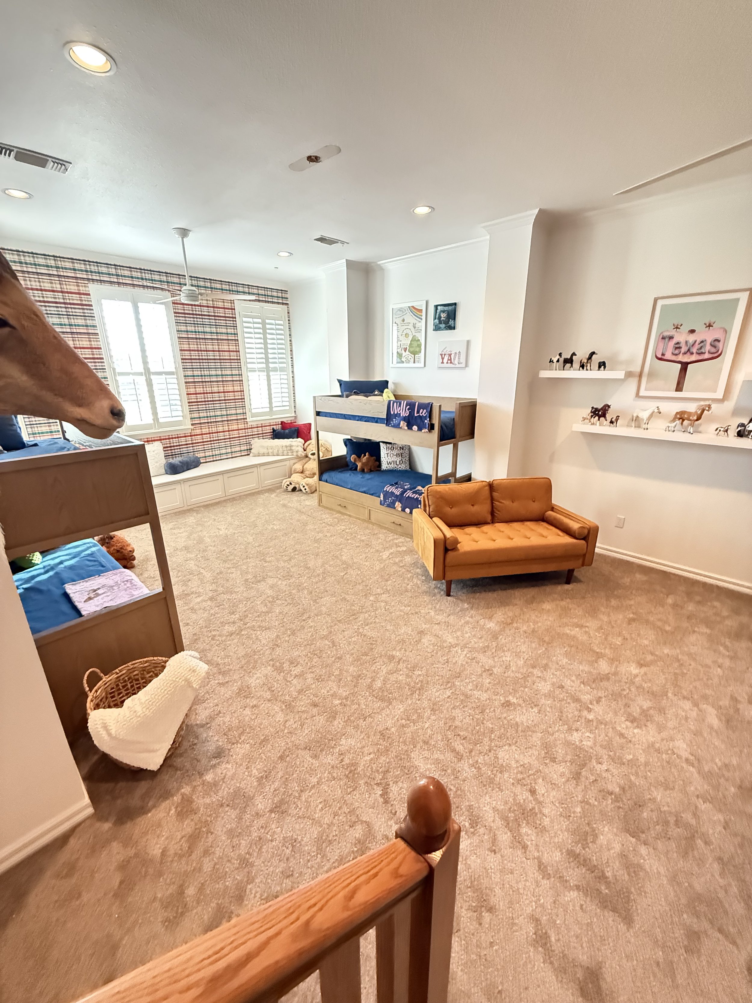 Custom grandkids playroom design in Texas with built-in window seating and playful modern decor with patterned wallpaper
