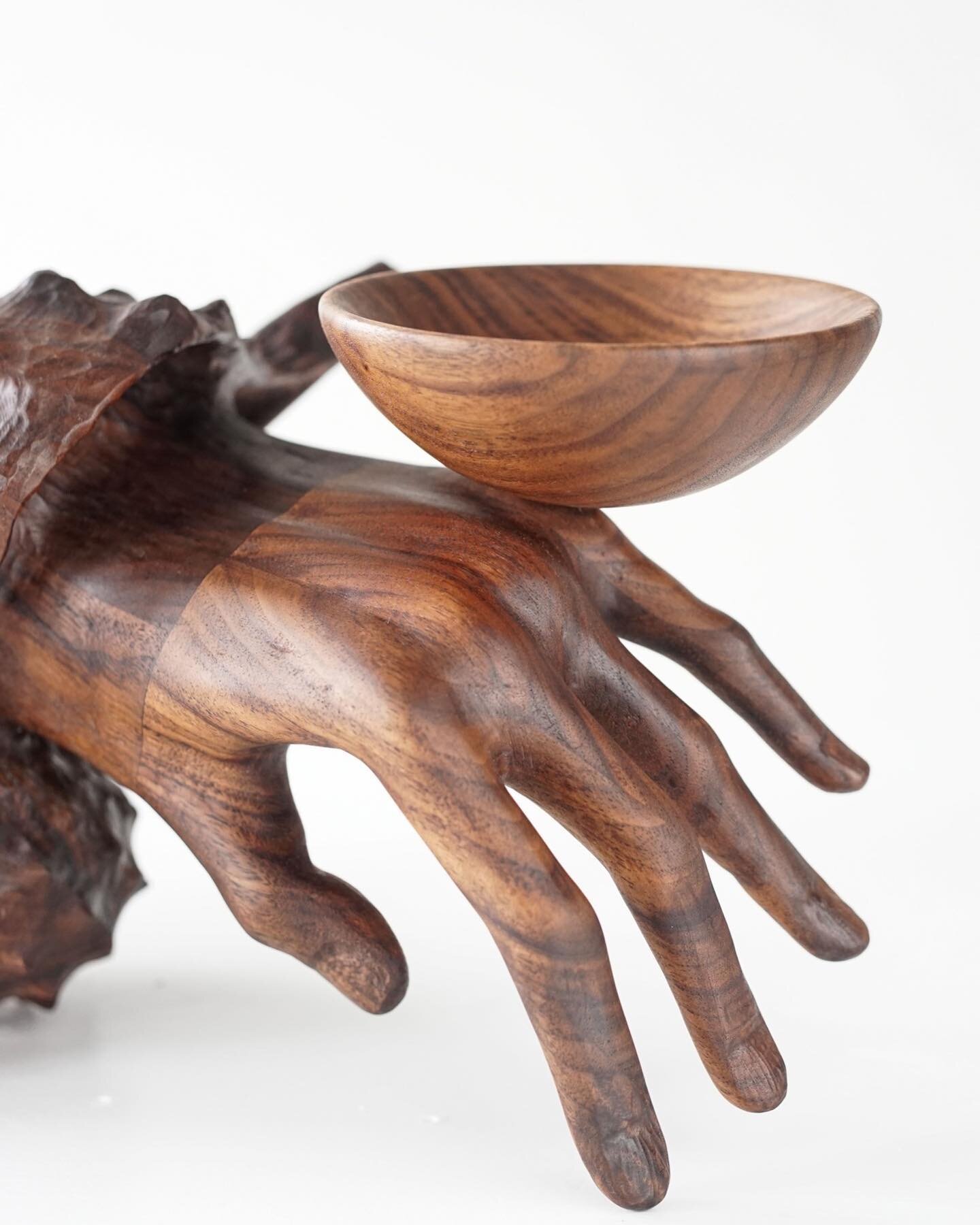 Vincent Pocsik creates a strange and delicate vision from carved black walnut. Emerging from a conch shell, a slender hand precariously balances a small bowl. Pocsik's work plays with functionality, humor, and the surreal. You can view it in person a