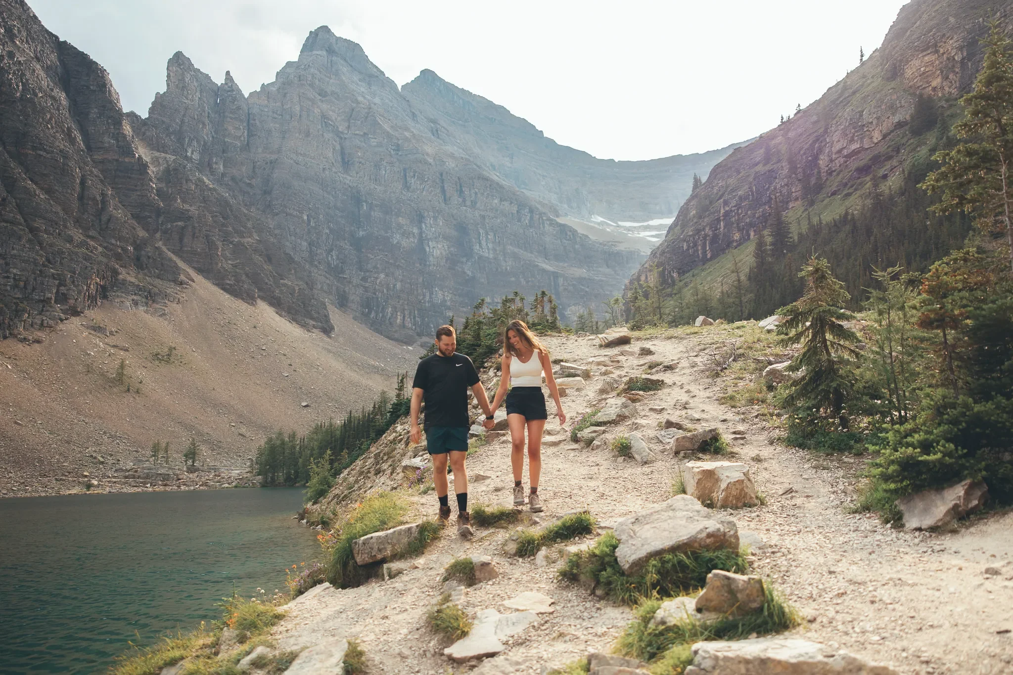 103_Couple-Walking-Rocky-Mountain-Trail-Alpine-Lake-Canadian-Rockies.webp