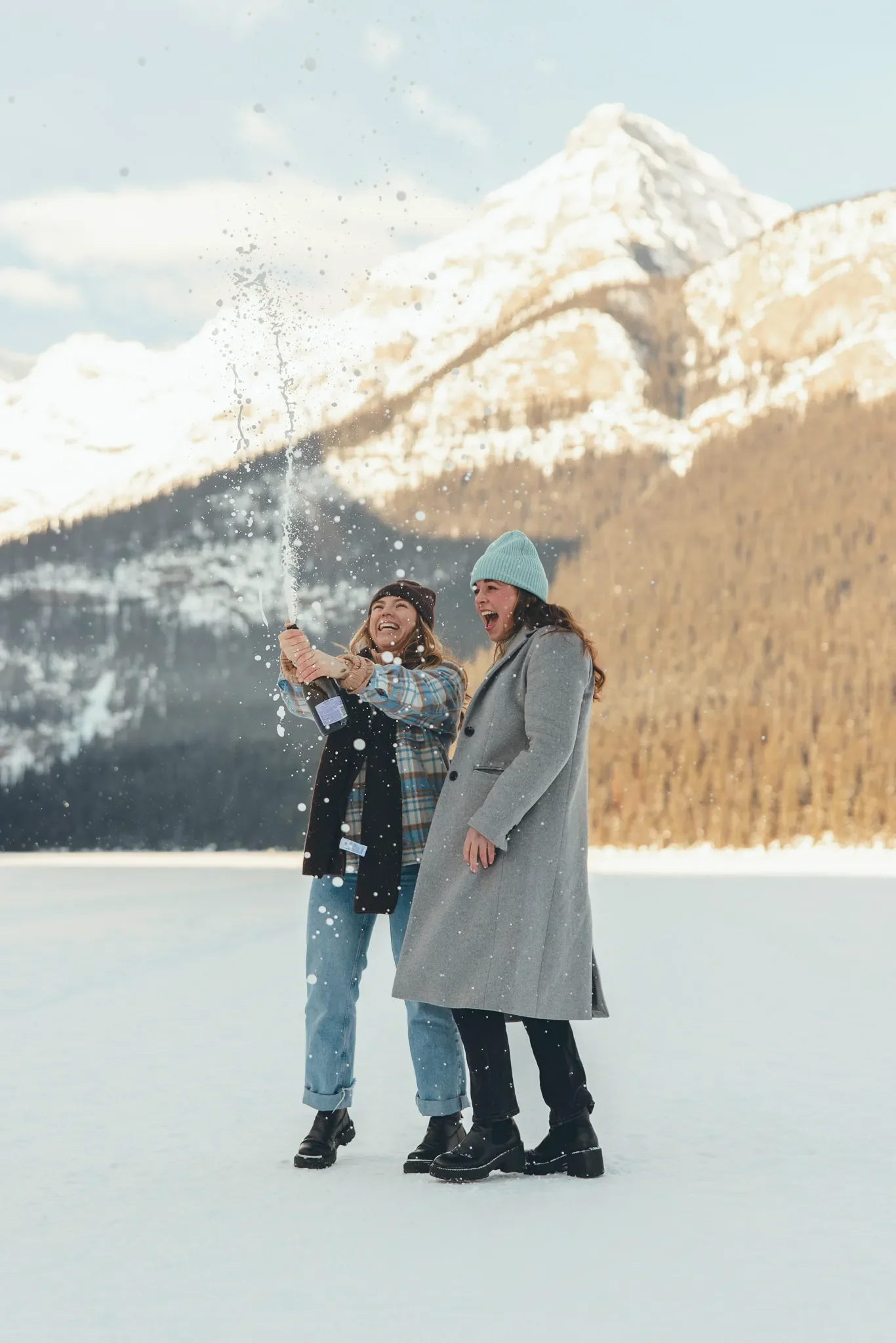 155_women-popping-champagne-celebration-lake-louise-canadian-rockies.webp