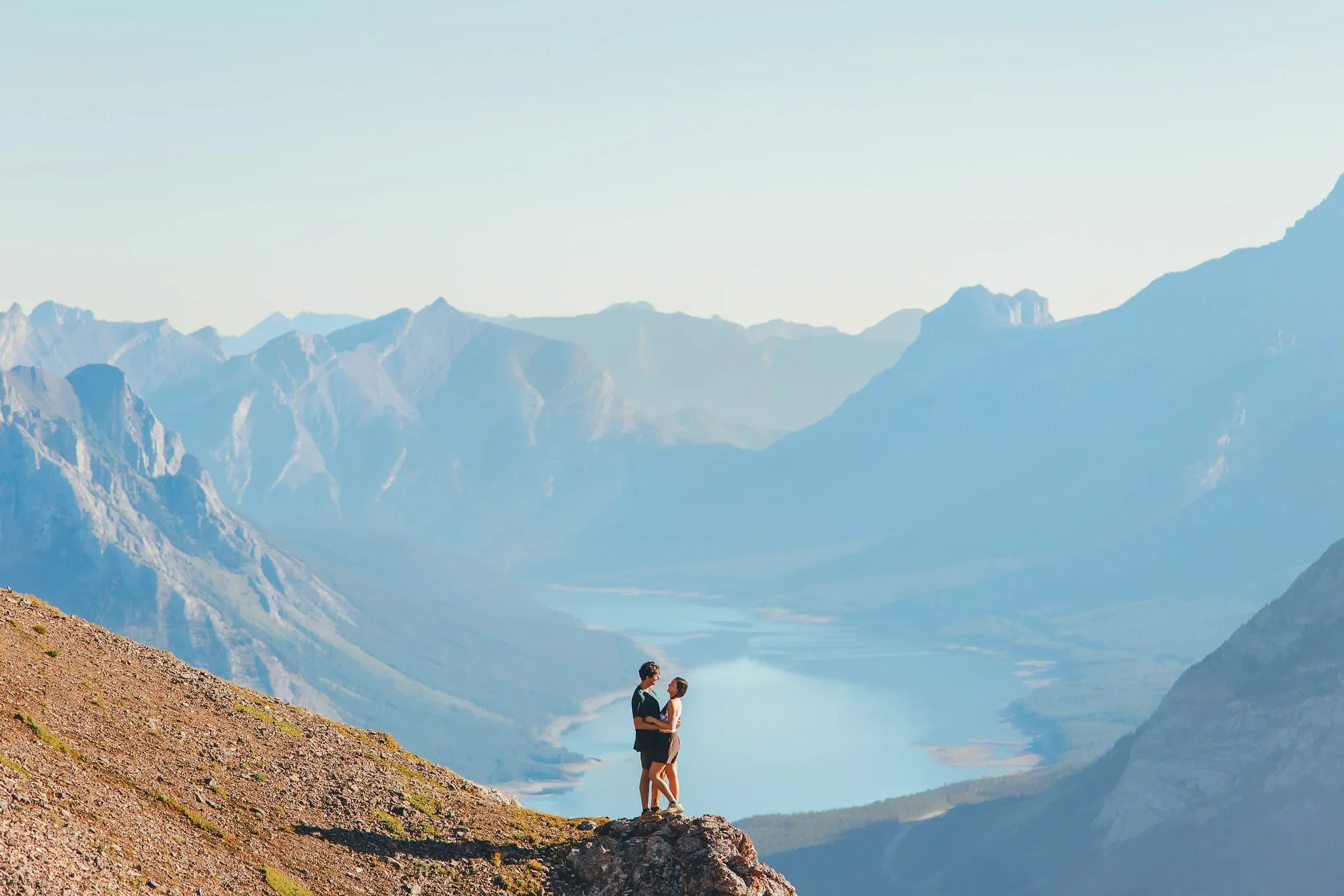 120_couple-standing-mountain-viewpoint-alpine-lake-canadian-rockies.webp
