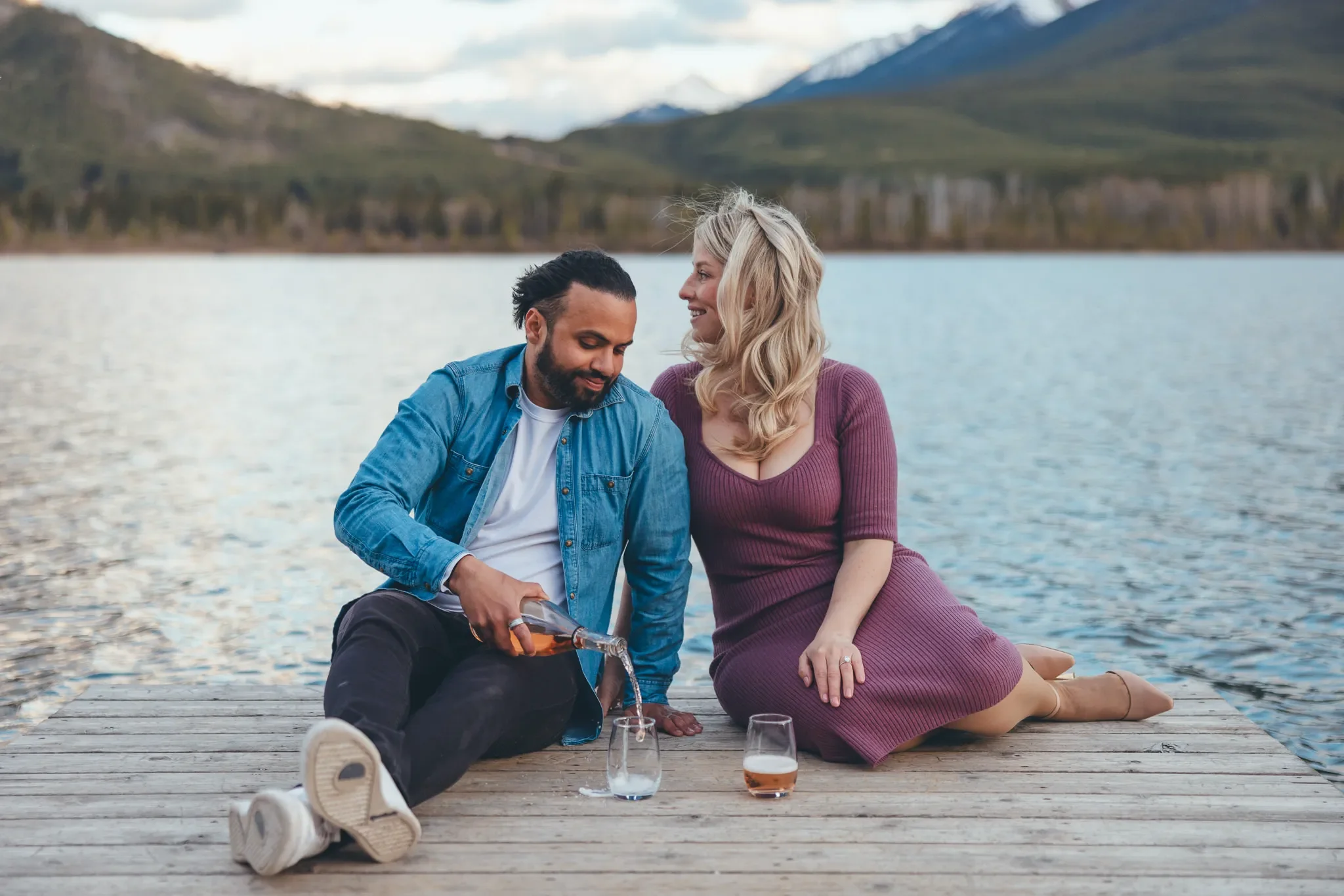 115_couple-engagement-pouring-wine-canadian-rockies-lake-dock.webp