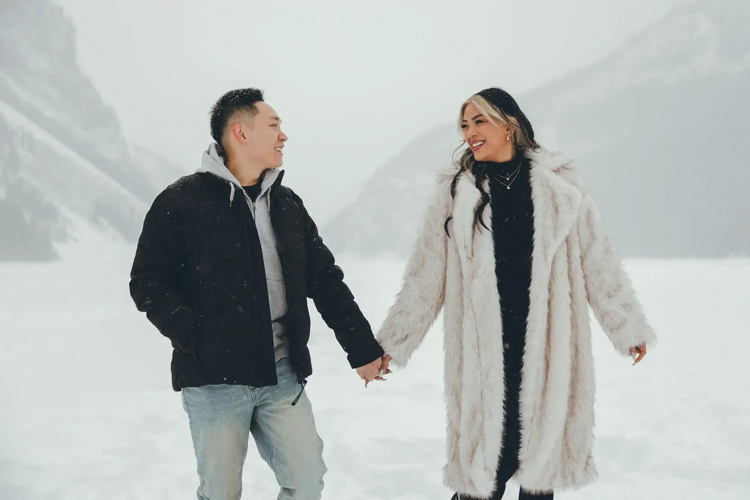 110_Couple-Walking-Frozen-Lake-Canadian-Rockies-Winter-Engagement.webp