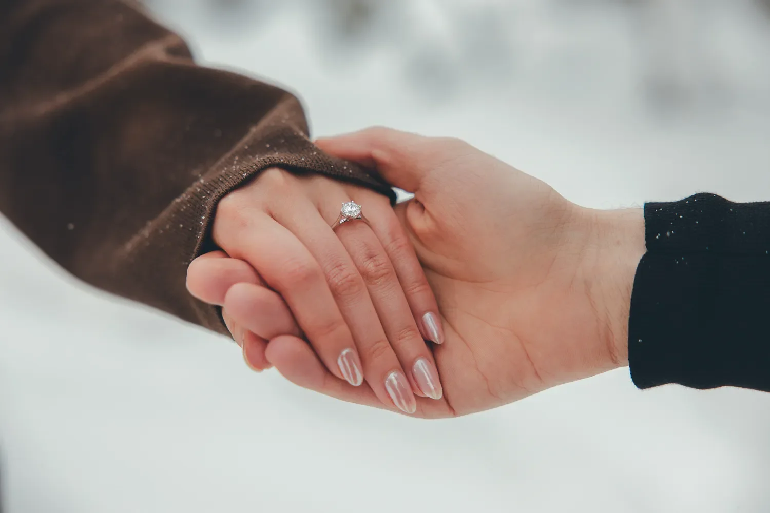120_Engagement-Ring-Couple-Holding-Hands-Winter-Snow.webp