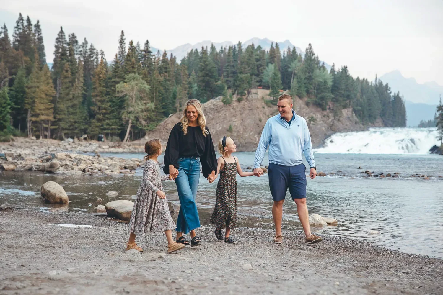 101_family-walking-bow-falls-banff-mountain-landscape.webp