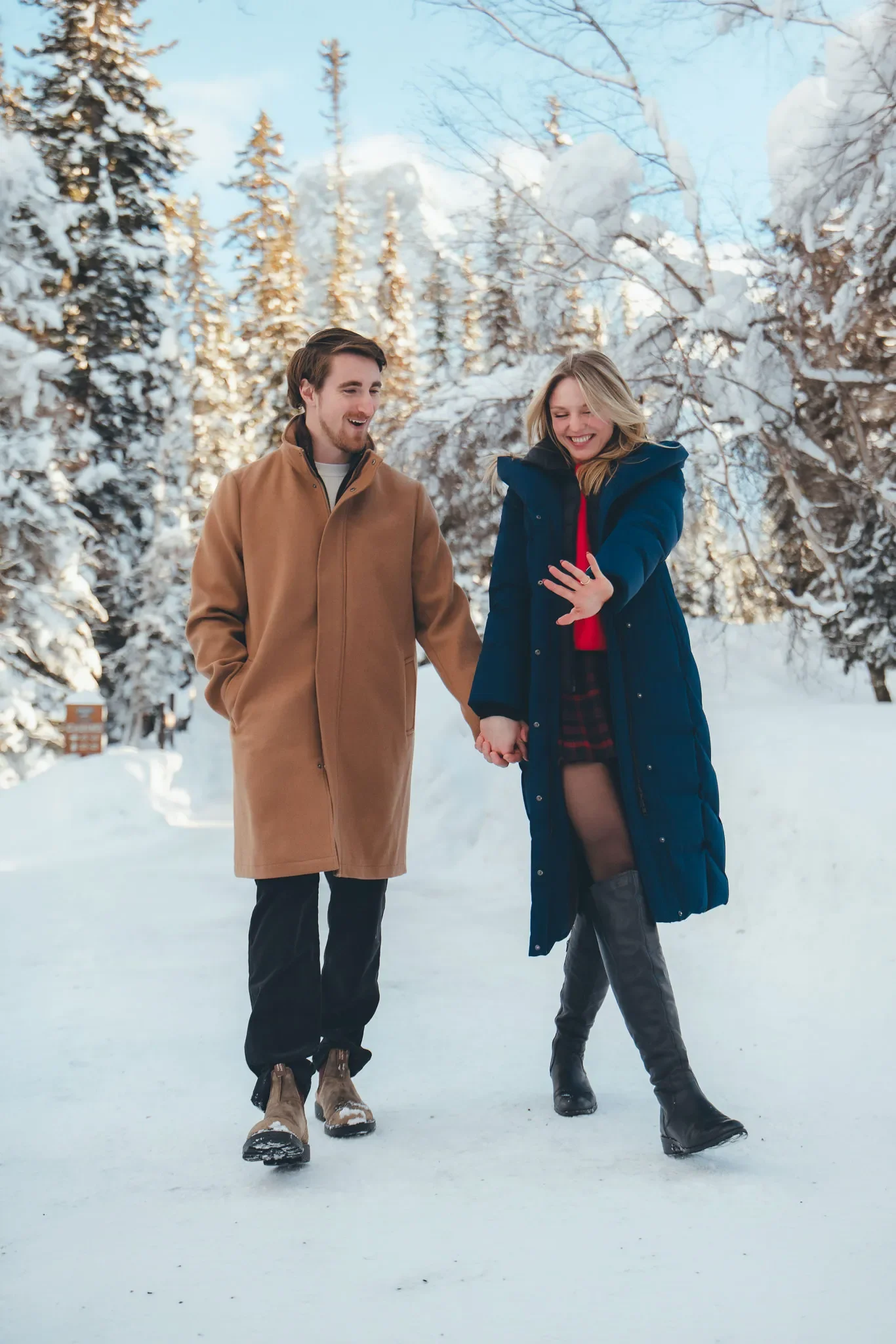 109_couple-engagement-walking-snowy-mountain-trail.webp