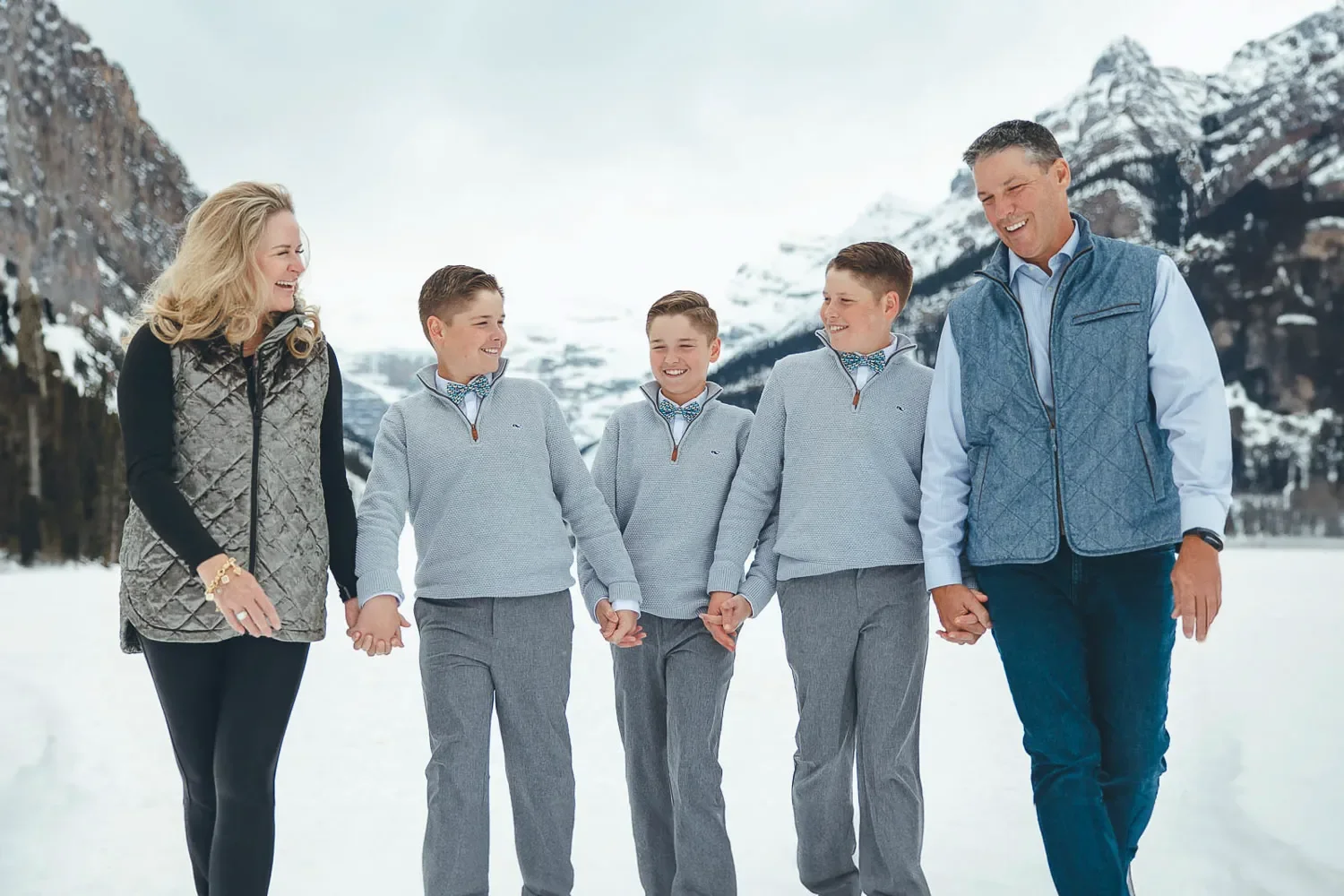 103_Family-Walking-Holding-Hands-Lake-Louise-Winter-Mountains.webp