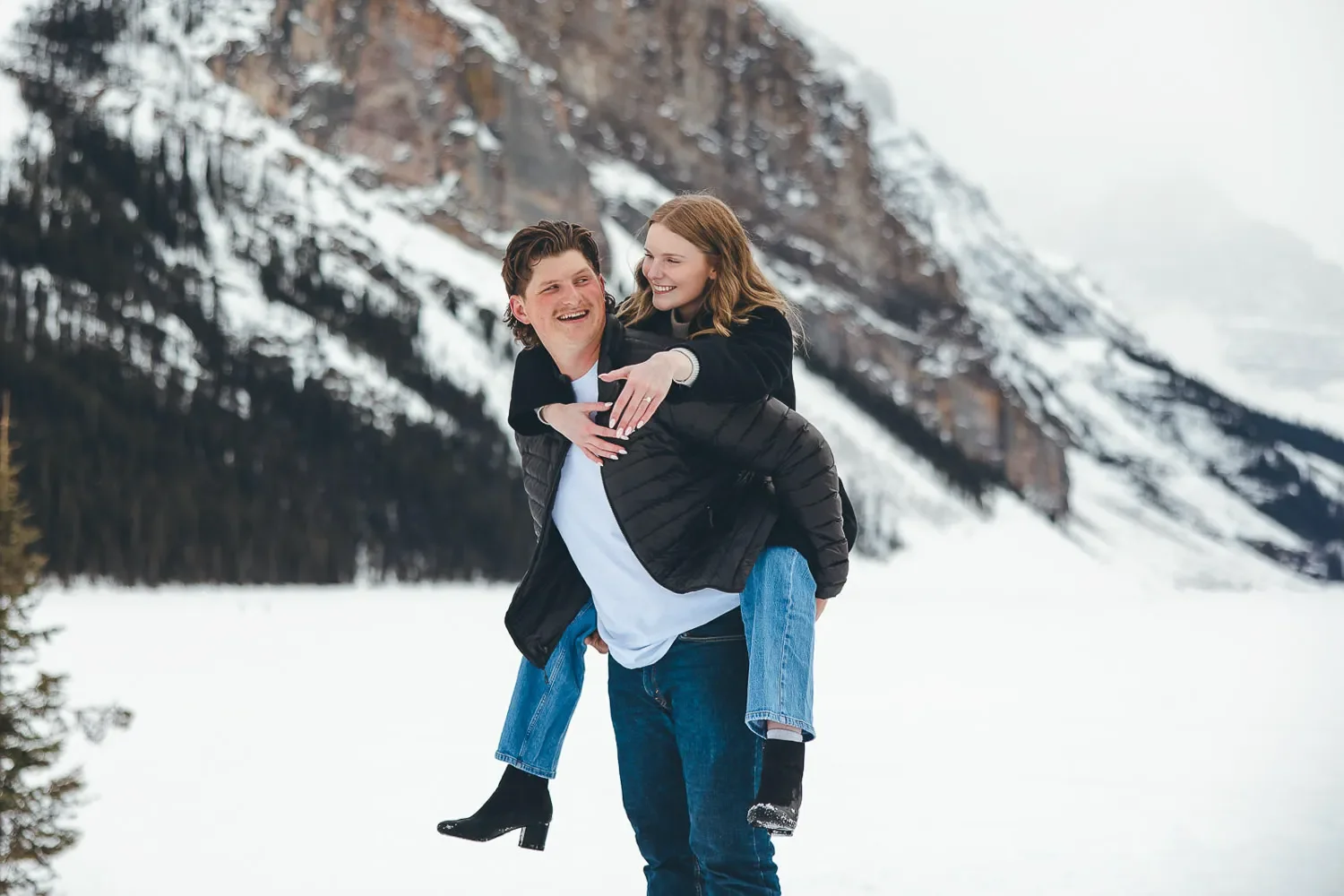114_engagement-couple-piggyback-ride-winter-mountain-landscape-canadian-rockies.webp