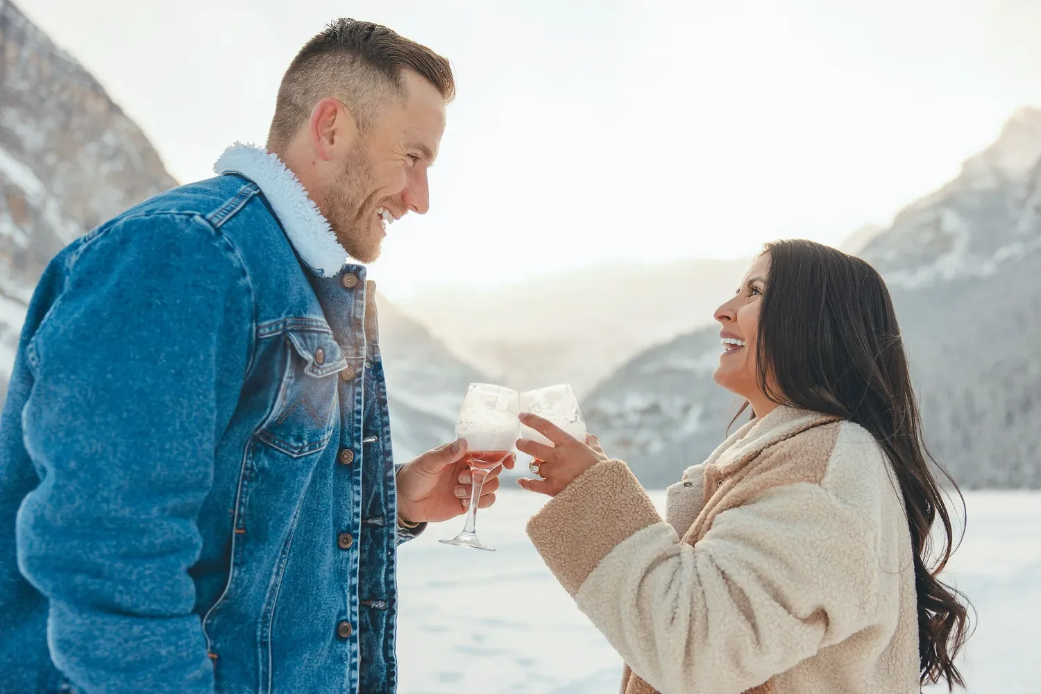 104_Couple-Toasting-Engagement-Celebration-Lake-Louise-Winter-Mountains.webp