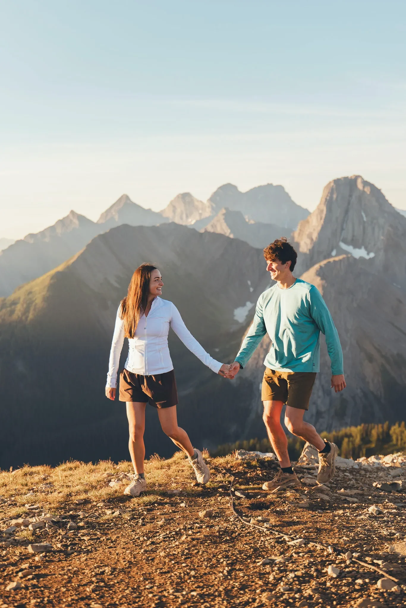 117_couple-holding-hands-hiking-mountain-viewpoint-canadian-rockies-golden-hour.webp